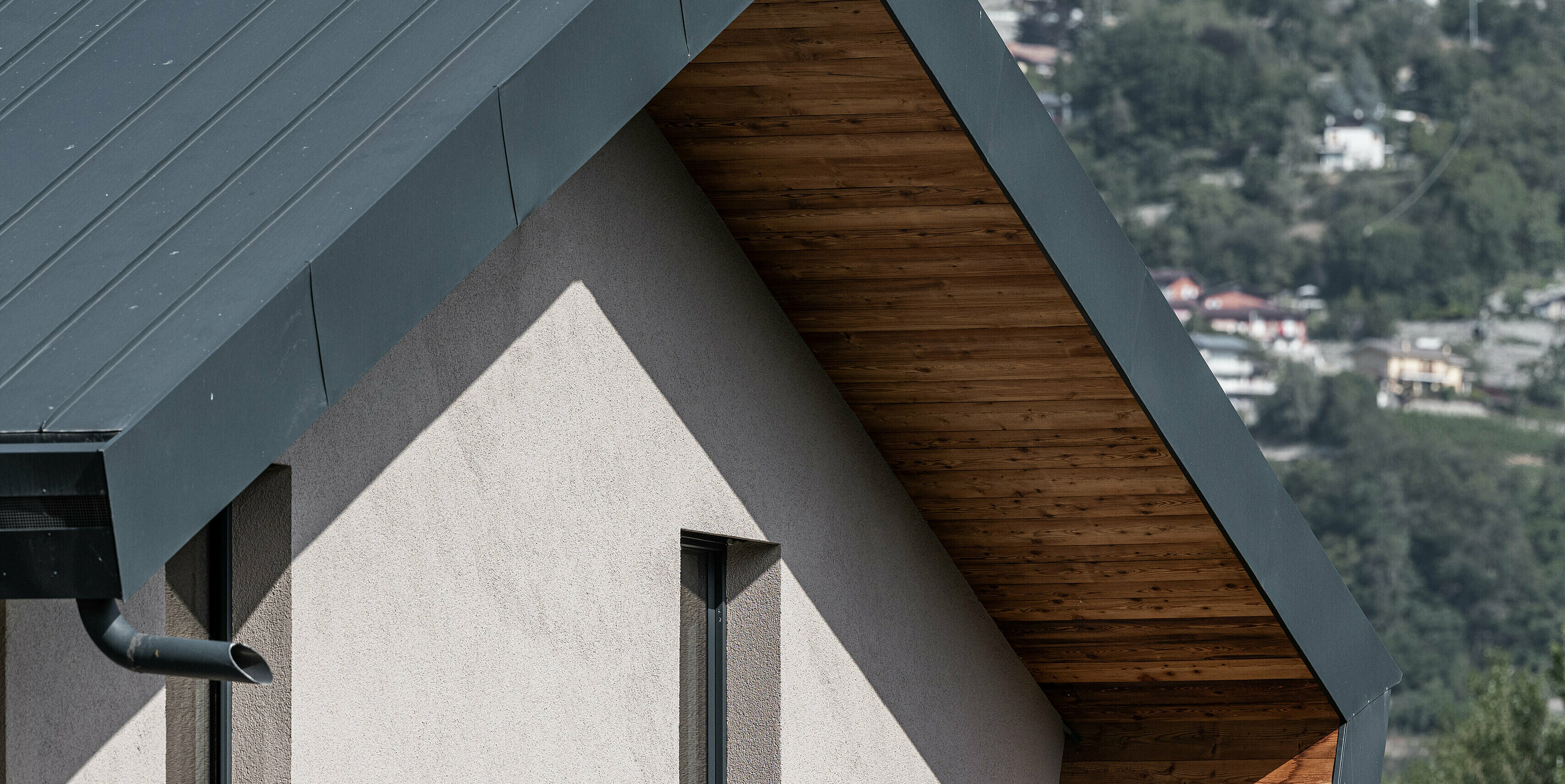 Detailansicht der Villa Tia in Italien, ausgestattet mit einem PREFA Komplettsystem. Zu sehen ist eine PREFALZ Aluminiumverkleidung in der Farbe P.10 Anthrazit, welche die warmen Holzunterkonstruktionen elegant zur Geltung bringt. Die präzise Verarbeitung und das zeitgenössische Design spiegeln die Qualität der PREFA Aluminiumprodukte wider, die für ihre Haltbarkeit und Ästhetik bekannt sind.