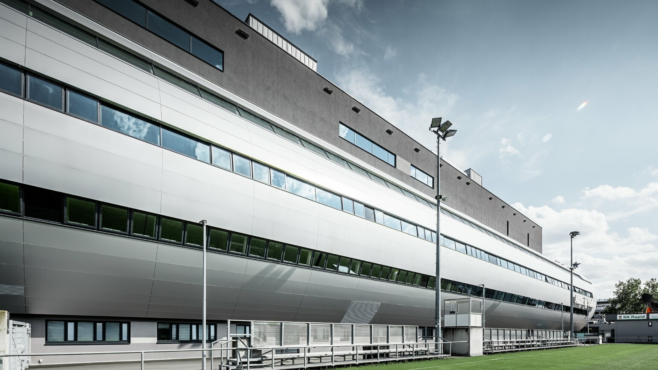 Widok wiedeńskiego Allianz Stadion z boiska treningowego. Rura prowadząca do wnętrza stadionu jest obłożona aluminiową płytą kompozytową PREFA w kolorze srebrny metalik.
