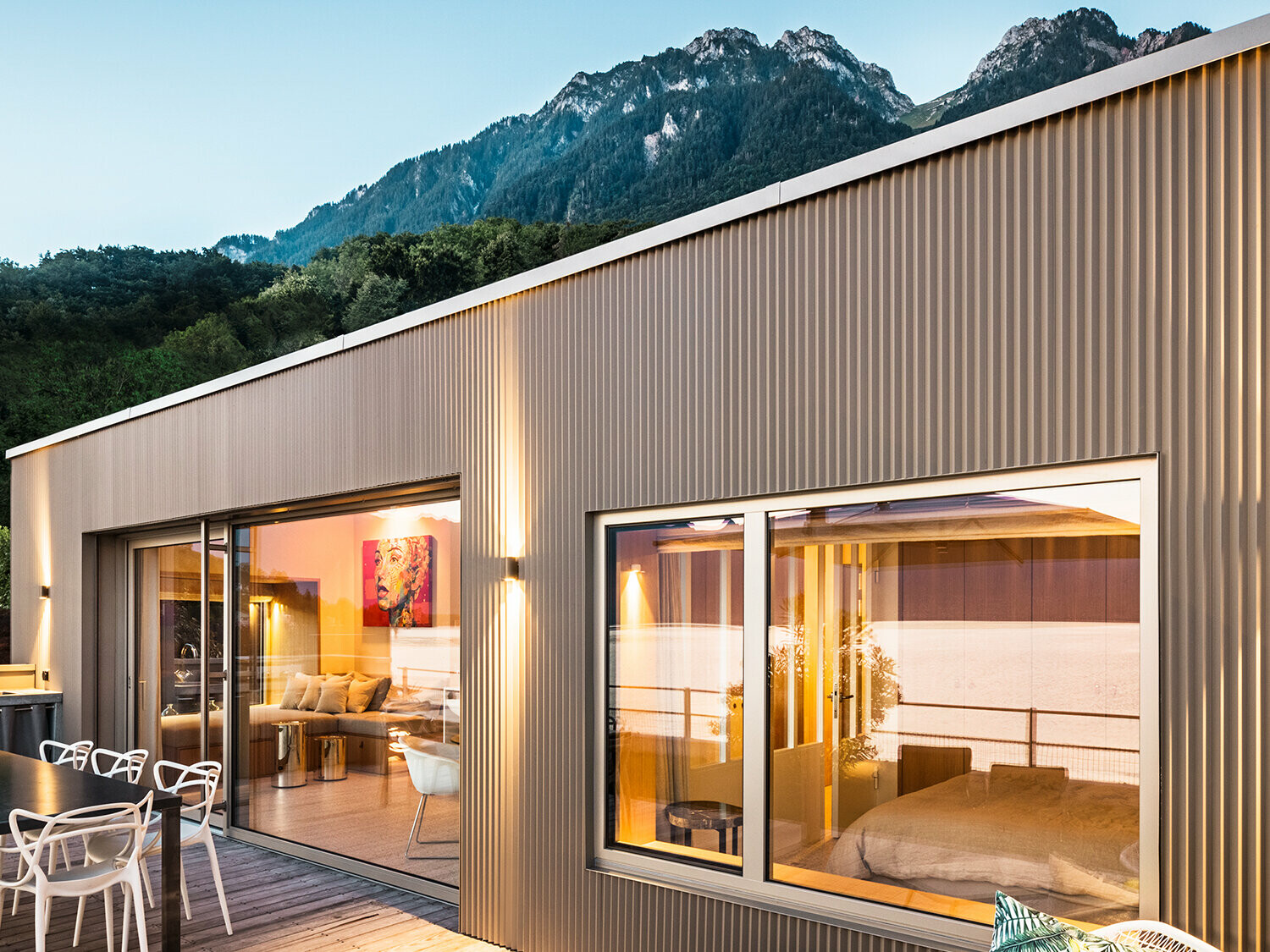 Widok na taras i część wnętrza budynku wieczorem.