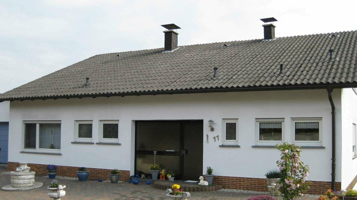 Dom jednorodzinny z falistym cementem włóknistym przed modernizacją dachu z płytą dachową PREFA