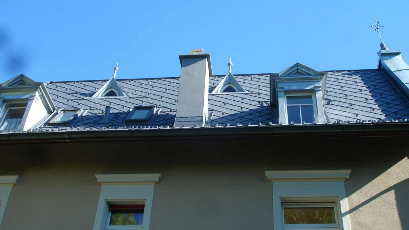Dach z fantazyjnymi oknami dachowymi — modernizacja dachu z dachówką rombową PREFA