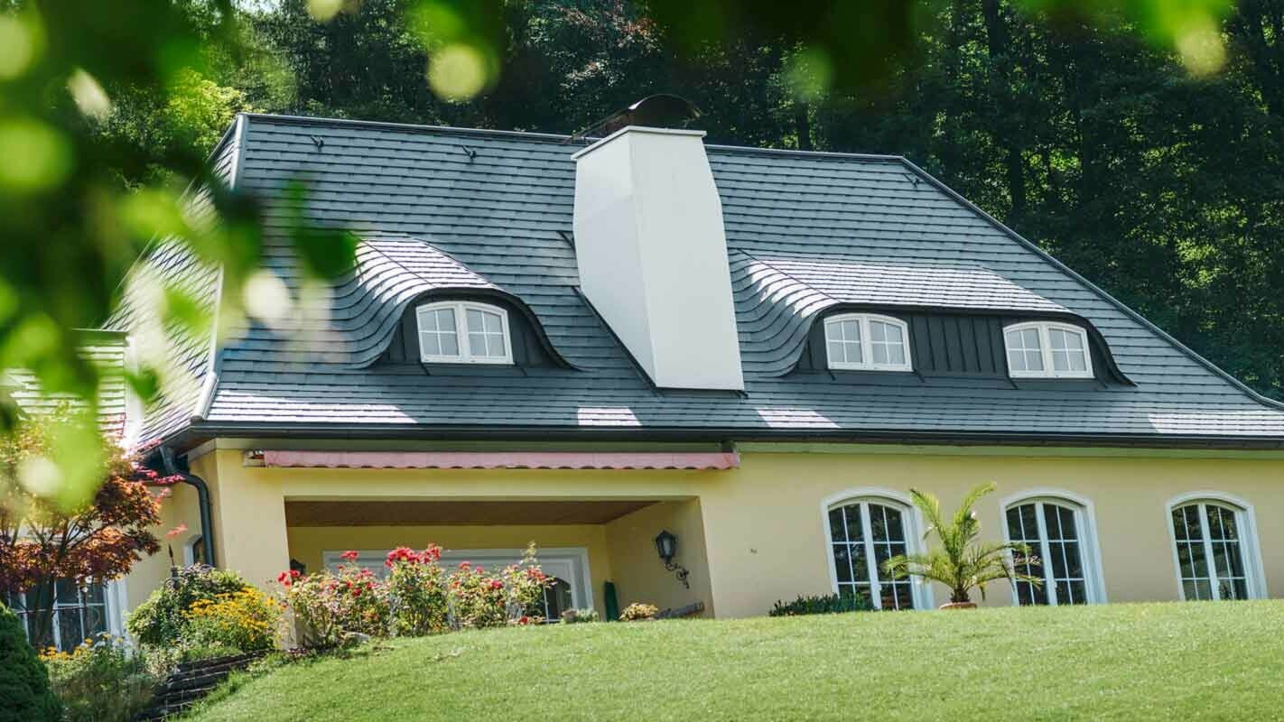 Dach budynku i wole oko przed modernizacją dachówką PREFA z dużym kominem