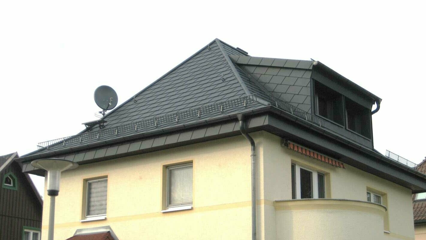 Modernizacja dachu czterospadowego z dachówką PREFA i oknem dachowym, żółta elewacja