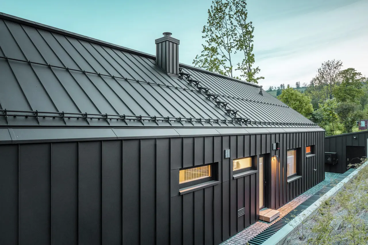 Das Bild zeigt ein Einfamilienhaus mit einem Dach und einer Fassade aus PREFALZ, Farbton P.10 Schwarz.