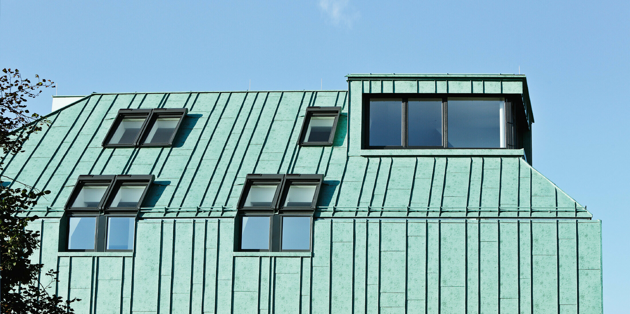 Dach i elewacja PREFALZ w kolorze zielonej patyny marki PREFA z różnymi szerokościami pasów blachy