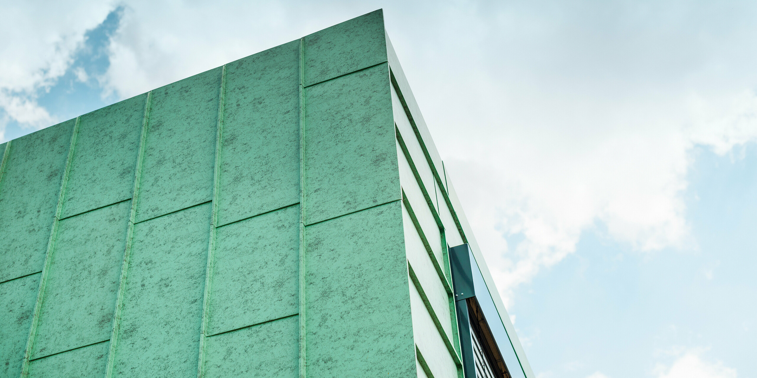 Das moderne Wohnhaus in Heidenheim wird von einer atemberaubenden PREFALZ Fassade in Patina Grün geziert, die in dieser Nahaufnahme besonders gut zur Geltung kommt. Die außergewöhnliche Farbgebung harmoniert perfekt mit der Architektur des Hauses und vermittelt sowohl zeitlose Eleganz als auch einen Hauch von Natur.