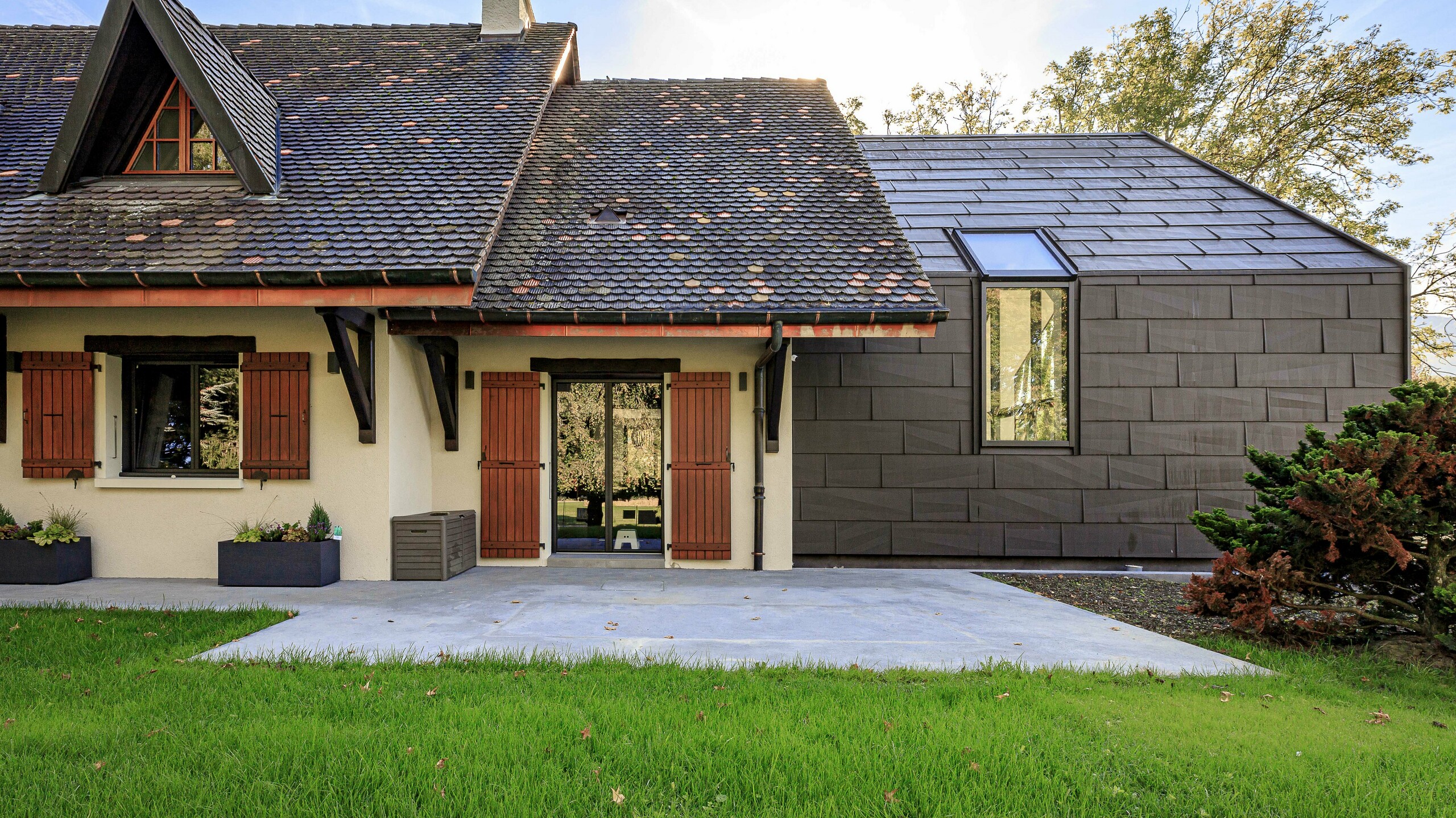 Panele dachowe i elewacyjne PREFA FX.12 w kolorze P.10 brązowym jako kontrastowy element dekoracyjny na dobudówce domu jednorodzinnego w Lully