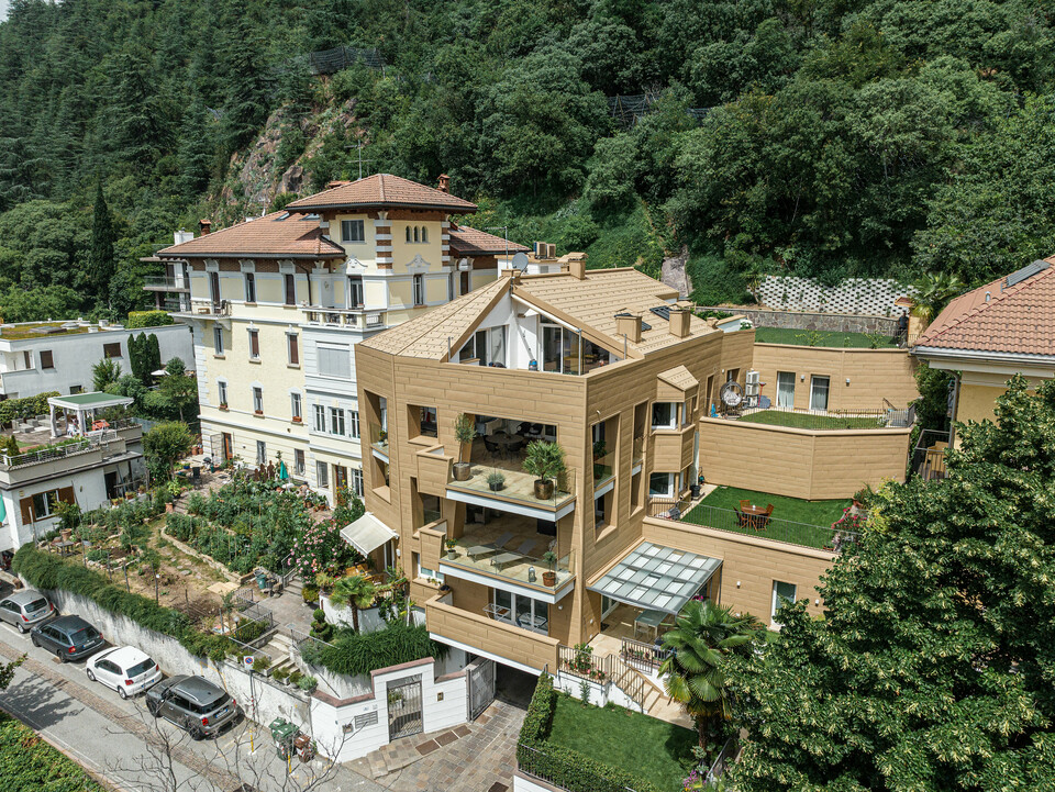 Architektonisches Meisterwerk: Die Villa Laura in Südtirol ist umhüllt von PREFA Aluminium in P.10 Sandbraun. Die innovativen Kantungen der Dachpaneele FX.12 und Siding.X prägen das einzigartige Design der Wohnanlage und verleihen ihr eine dynamische und moderne Ausstrahlung, die nahtlos mit der umgebenden Natur verschmilzt. Das hochwertige und langlebige Aluminium gewährleistet eine elegante Ästhetik sowie eine dauerhafte Beständigkeit gegen Witterungseinflüsse.