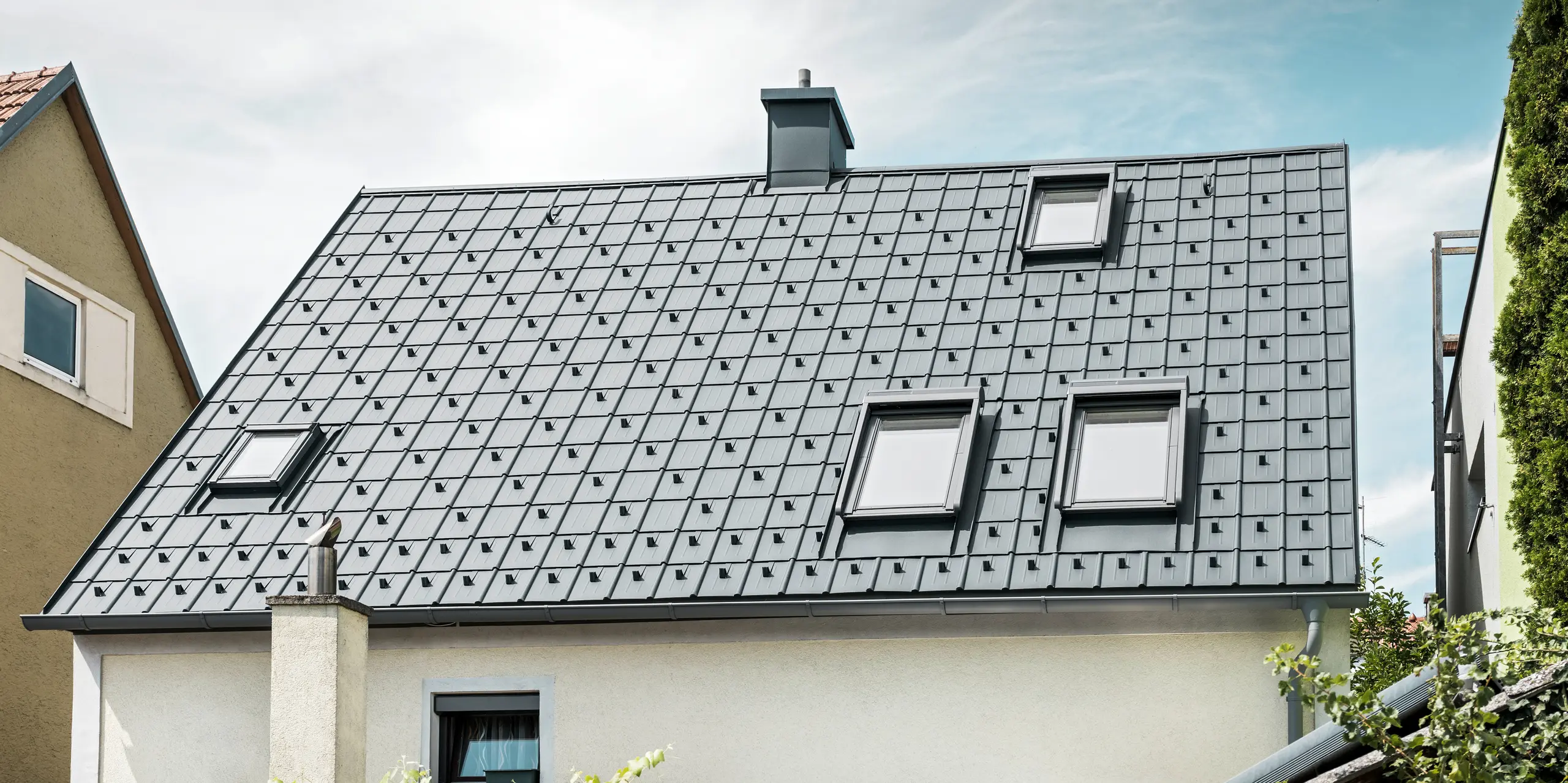 Einfamilienhaus in St. Valentin mit PREFA Dachplatte in anthrazit und einem Dachentwässerungssystem von PREFA in hellgrau