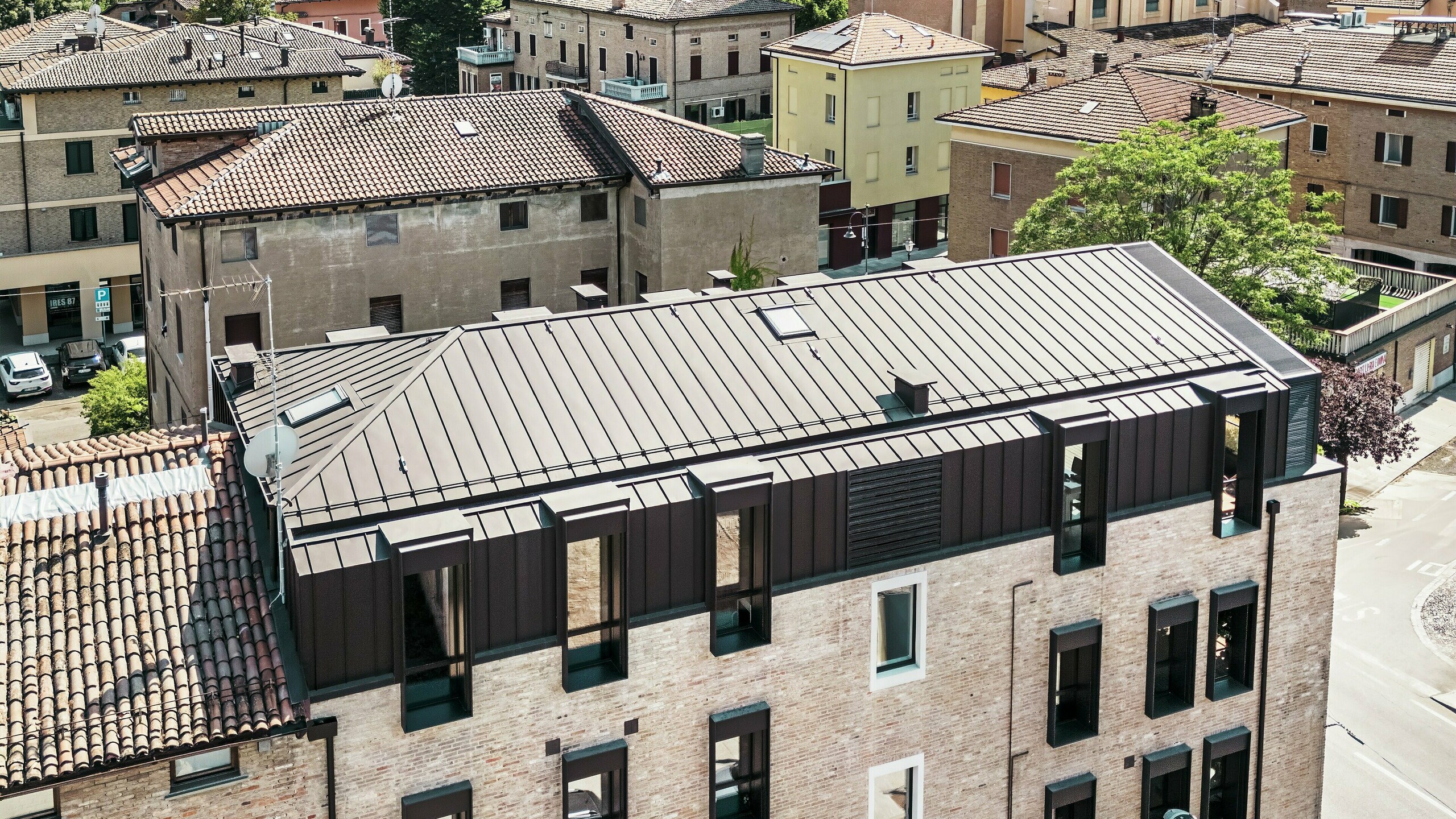 Zmodernizowany dom z cegły we Włoszech z dachem aluminiowym PREFALZ w kolorze P.10 orzechowy brąz – estetyczne połączenie tradycyjnej architektury ceglanej z nowoczesnym, trwałym rozwiązaniem dachowym.