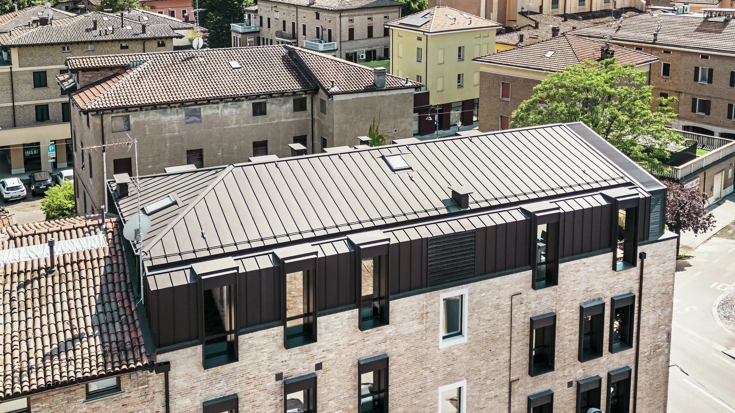 Zmodernizowany dom z cegły we Włoszech z dachem aluminiowym PREFALZ w kolorze P.10 orzechowy brąz – estetyczne połączenie tradycyjnej architektury ceglanej z nowoczesnym, trwałym rozwiązaniem dachowym.