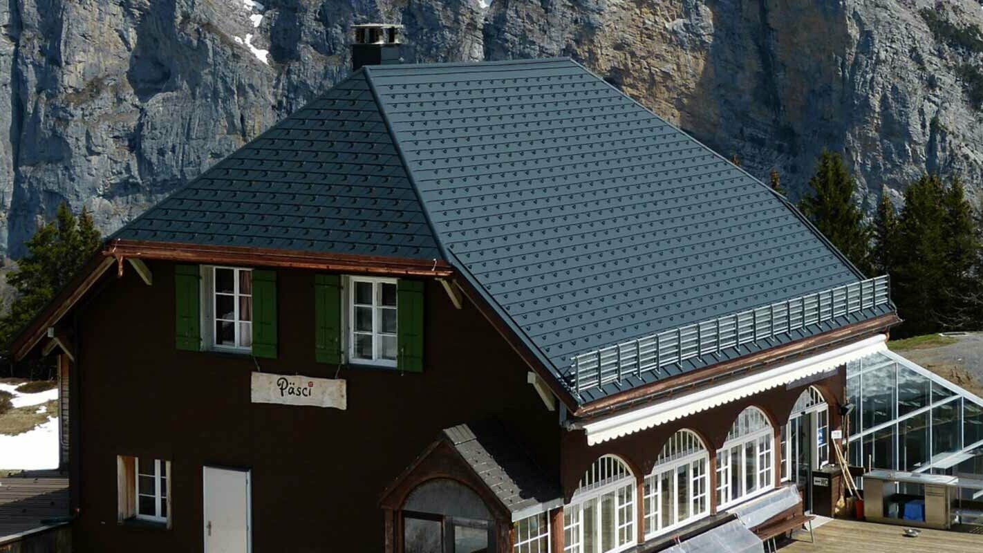Modernizacja dachu górskiej chaty z dachem półszczytowym, z dachówką PREFA i stoperami śniegowymi