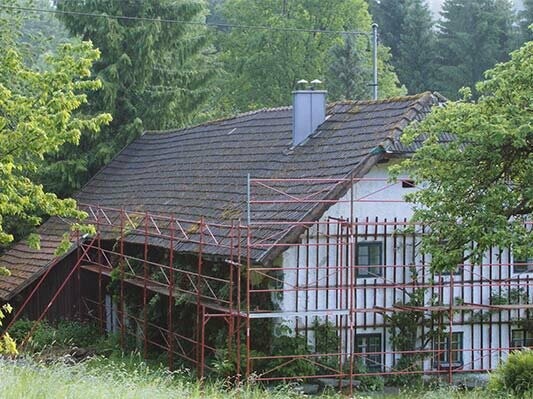 stary dach budynku Wiesenhaus przed remontem z użyciem dachówek łupkowych PREFA (z rusztowaniem).