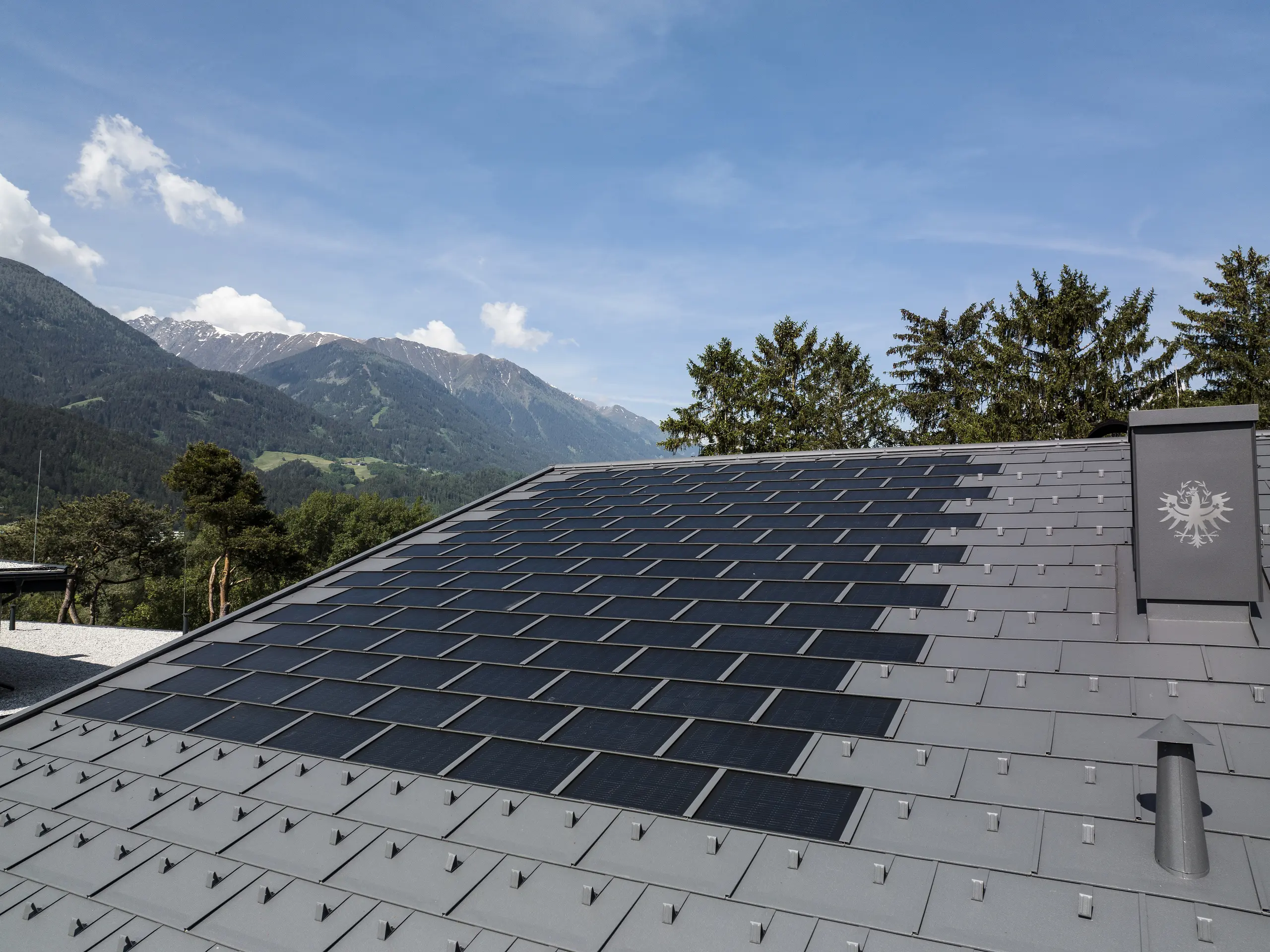 Zdjęcie dachu w Tyrolu pokrytego panelem dachowym PREFA Solar R.16 w kolorze ciemnoszarym P.10