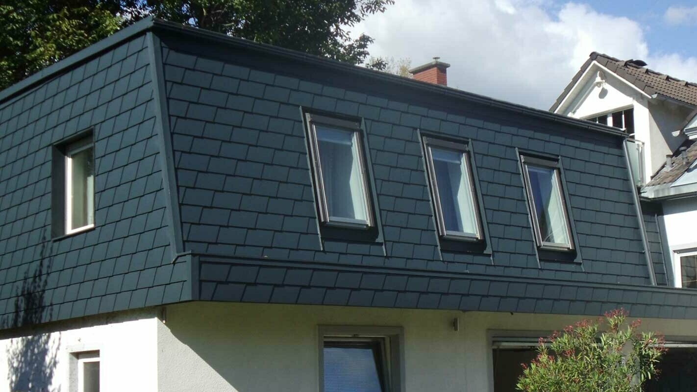 Rozbudowa dachu z dachówką PREFA, nowoczesna nadbudowa kondygnacji w kolorze antracytowym z licznymi oknami