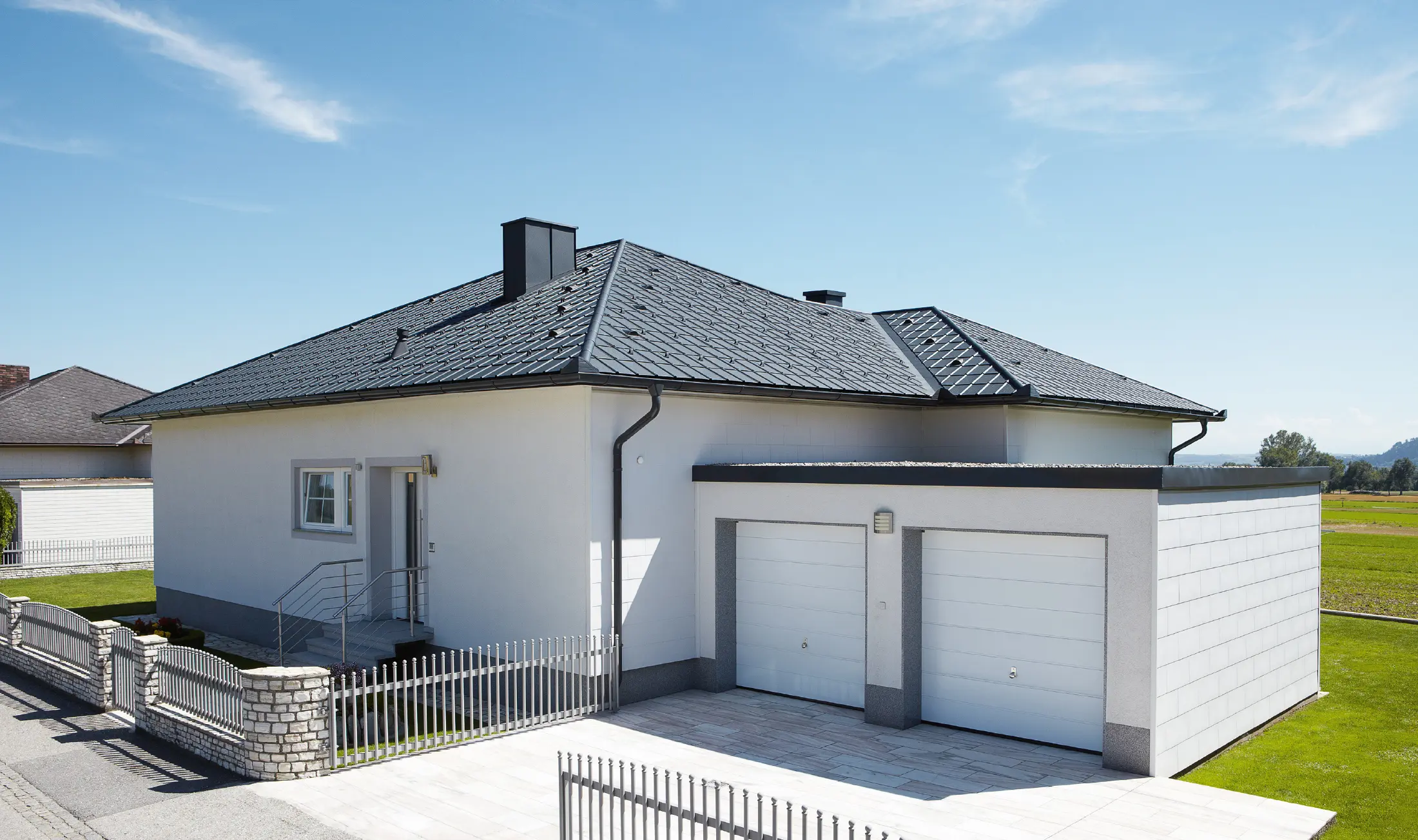 Nowo wybudowany bungalow z dachem namiotowym został pokryty dachówka klasyczna PREFA w kolorze P.10 antracyt. Podwójny garaż został dodany po prawej stronie, sfotografowany od ulicy.