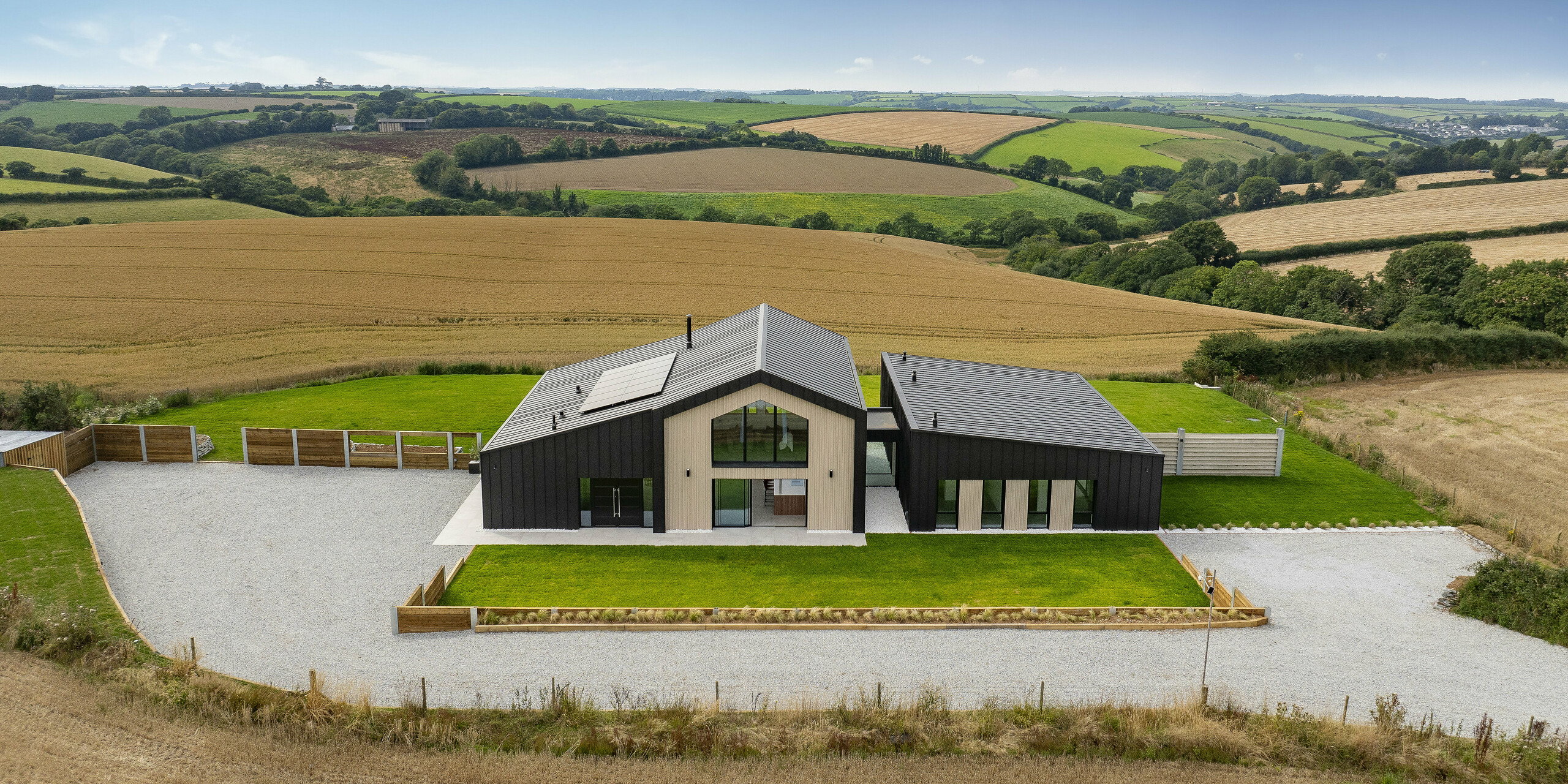 Das beeindruckende Einfamilienhaus ‚The Hide‘ in Cornwall fügt sich harmonisch in die weite Landschaft ein. Die moderne Architektur mit Dach und Fassade aus PREFALZ Aluminium in P.10 Anthrazit verleiht dem Objekt eine zeitlose Eleganz. Die Umgebung aus Feldern und Hügeln unterstreicht die einzigartige Lage.