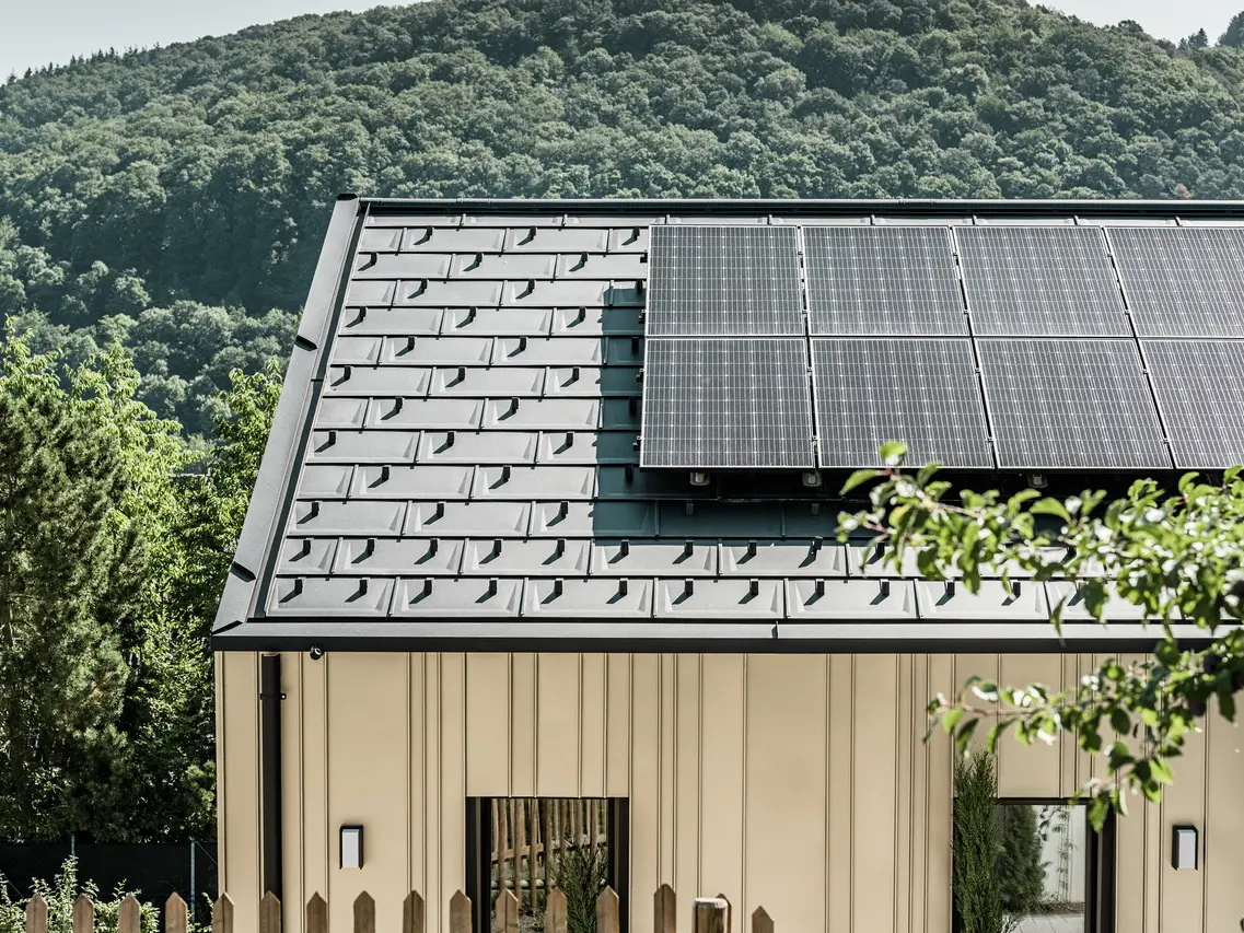 Widok na dom jednorodzinny pokryty DS.19 z systemem montażowym PREFA do instalacji solarnej.