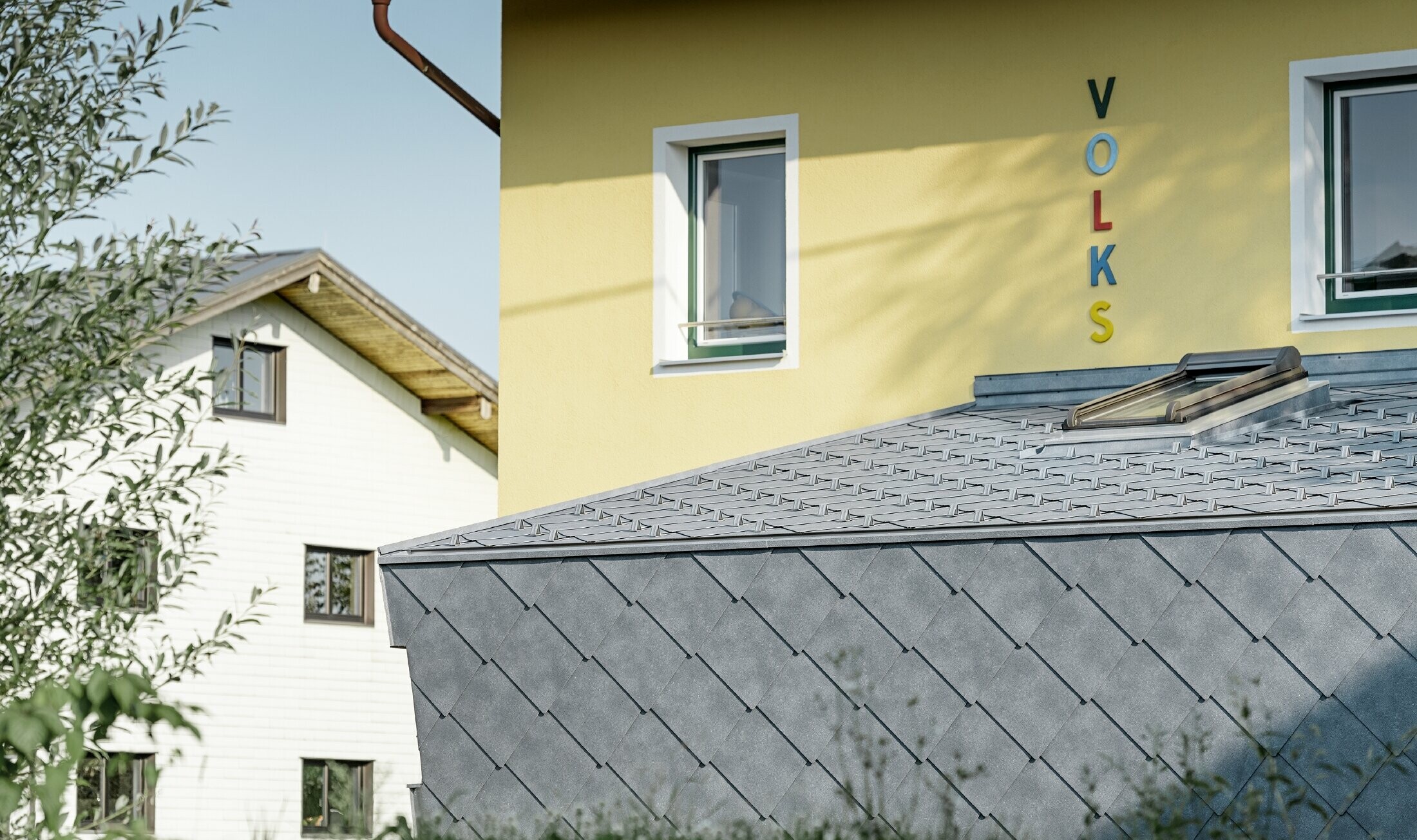 Dobudówka szkoły pokryta aluminiowym rombem ściennym i dachowym PREFA w kolorze kamiennym szarym