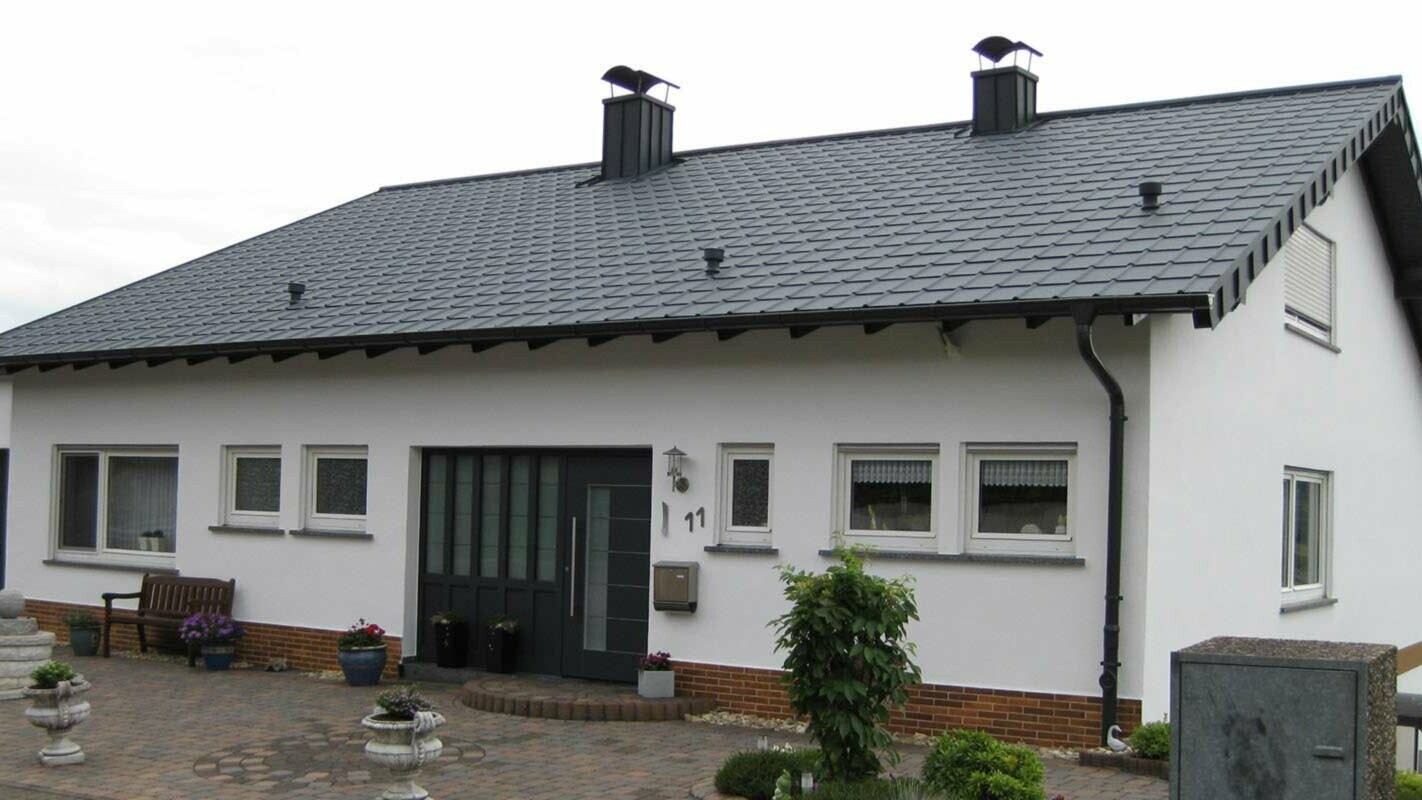 Dom jednorodzinny z prostym dachem szczytowym po modernizacji dachu z płytą dachową PREFA