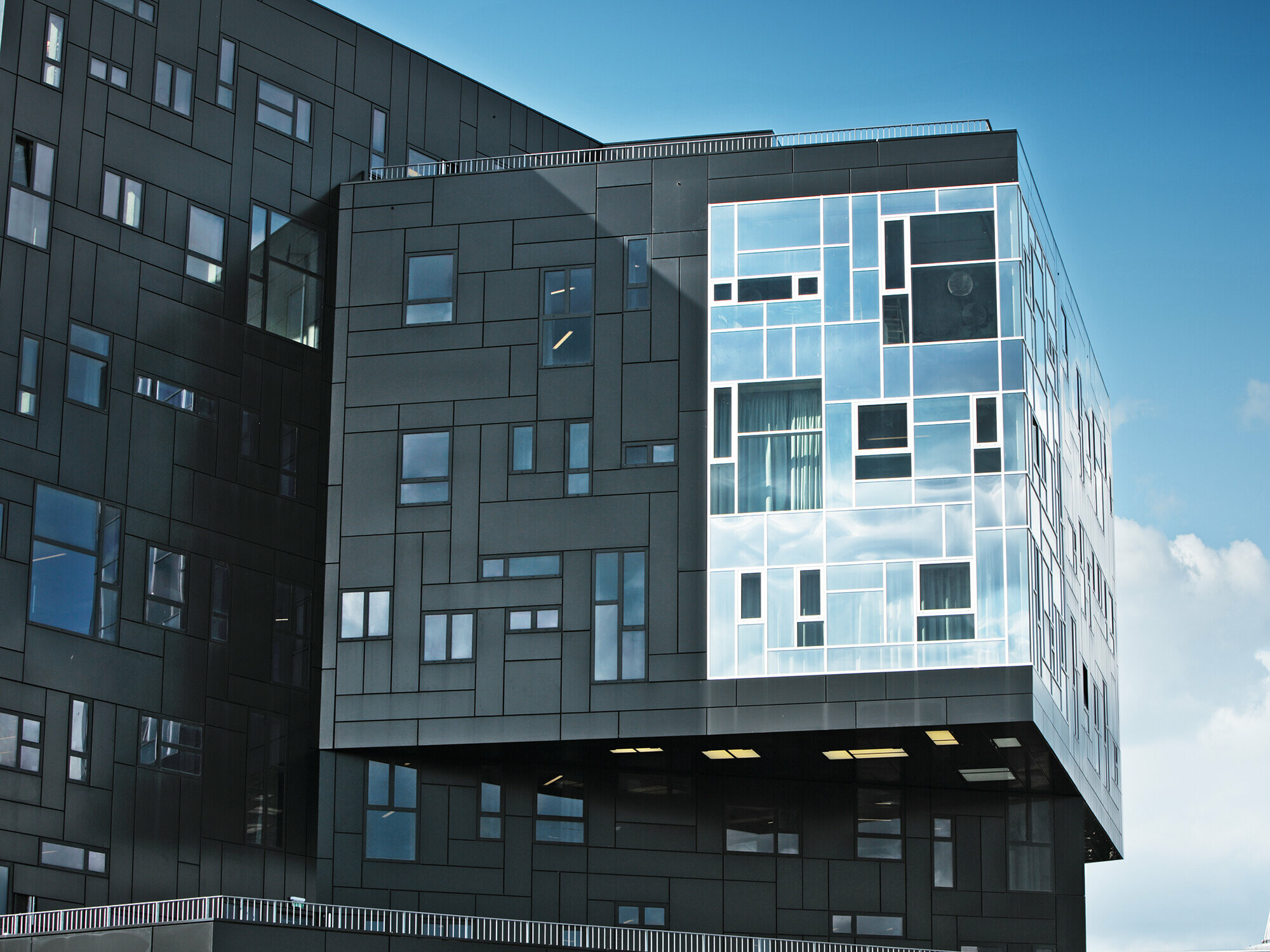 Zdjęcie wykonane przez WU Executive Academy, skupiające się na fasadzie z aluminiowych płyt kompozytowych PREFA w kolorze głębokiej czerni i błyszczącej części okiennej.