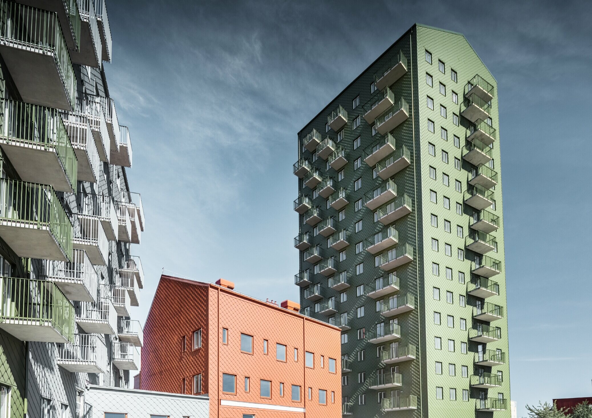 Różne bloki mieszkalne z poszyciem elewacji z rombu fasadowego PREFA 29 × 29 w kolorach oliwkowym, ceglastym i jasnoszarym, Göteborg, Szwecja.