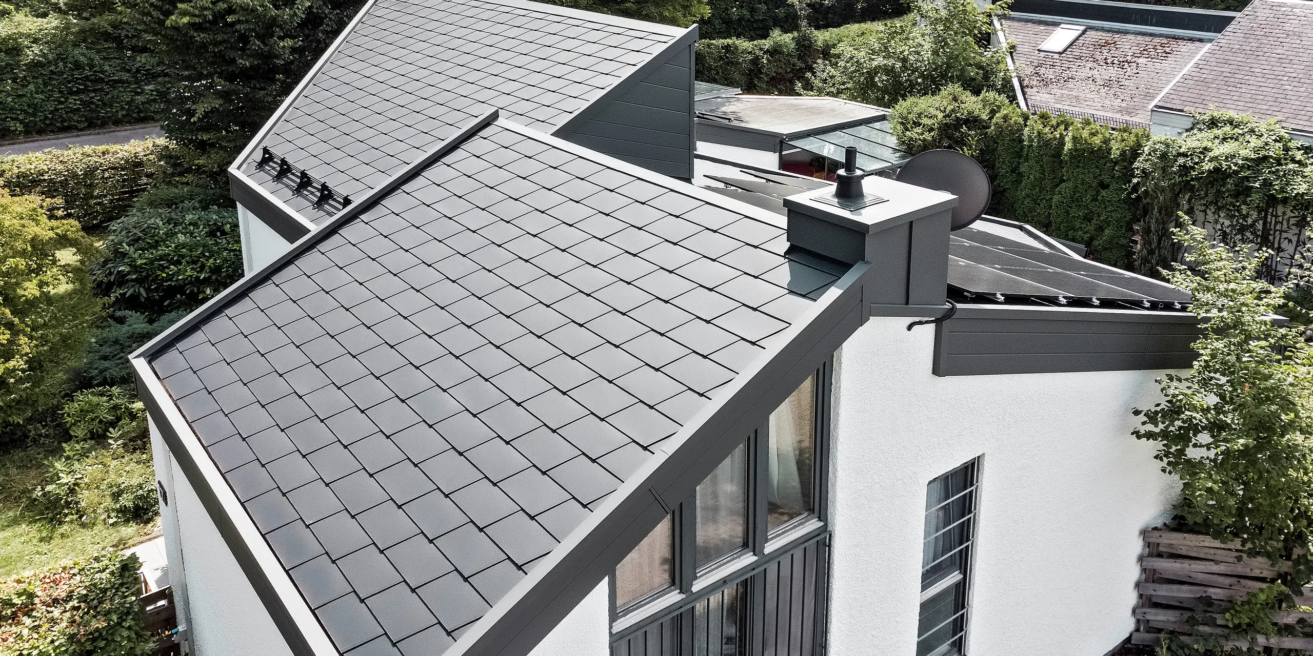 Ein Einfamilienhaus, das mit PREFA Dachschindeln DS.19 in schwarz eingedeckt wurde. Für Teile der Fassade wurden PREFA Sidings in P.10 dunkelgrau verwendet. 