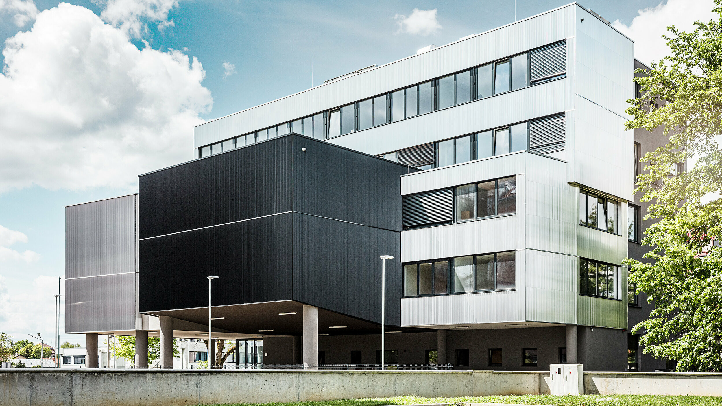 Seitenansicht der Musikschule in Bjevolar mit einer modernen PREFA Fassade im Zackenprofil. Die Fassade ist in Schwarz und aluminiumblank gehalten, und die geometrischen Formen sorgen für ein markantes, minimalistisches Design.