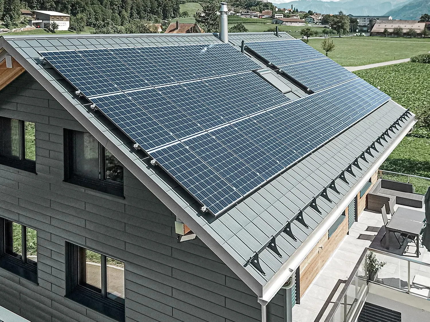 Instalacja fotowoltaiczna zamontowana na dachu PREFA z wspornikami solarnymi i szyną montażową do stabilnego mocowania.