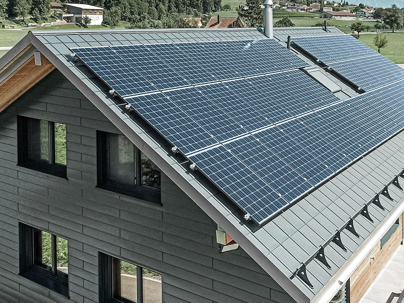 Instalacja fotowoltaiczna zamontowana na dachu PREFA z wspornikami solarnymi i szyną montażową do stabilnego mocowania.
