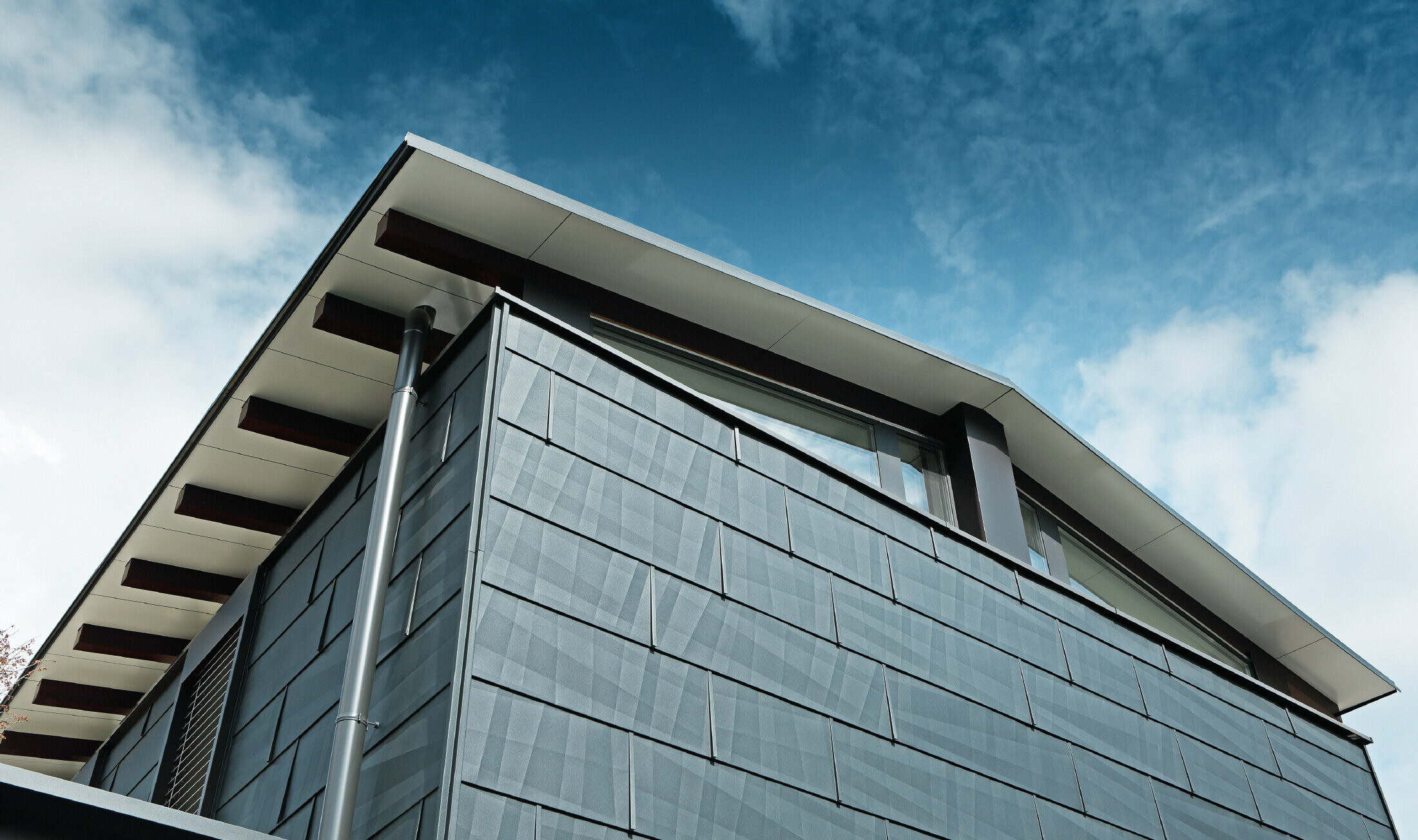 Aufnahme der Dachuntersicht, verkleidet mit der Aluminium Verbundplatte in Weiß, die Fassade wurde mit dem Fassadenpaneel FX.12 in Anthrazit bekleidet