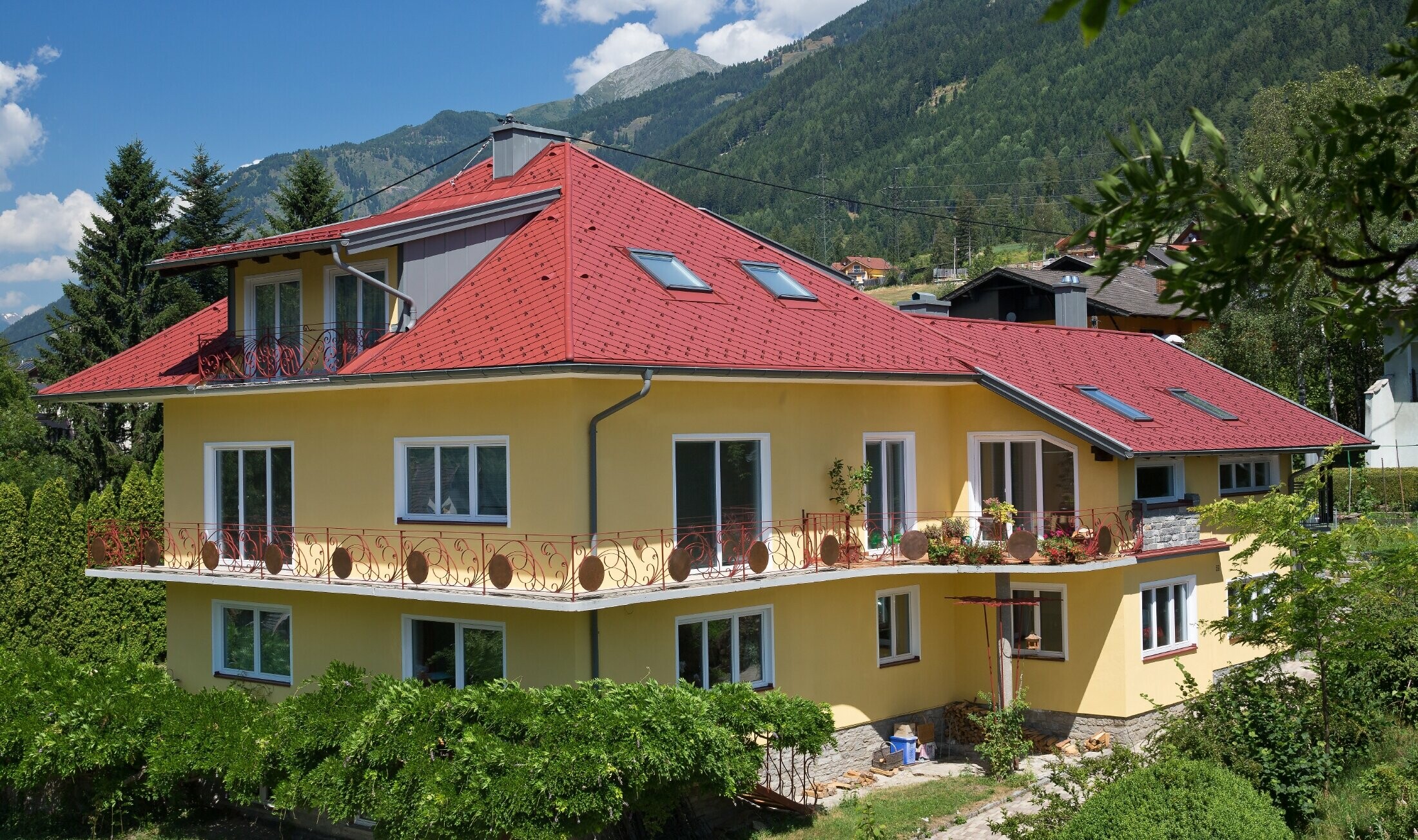 klasyczny dom jednorodzinny z dachem czterospadowym, pokryty dachówką romb w kolorze czerwonym.
