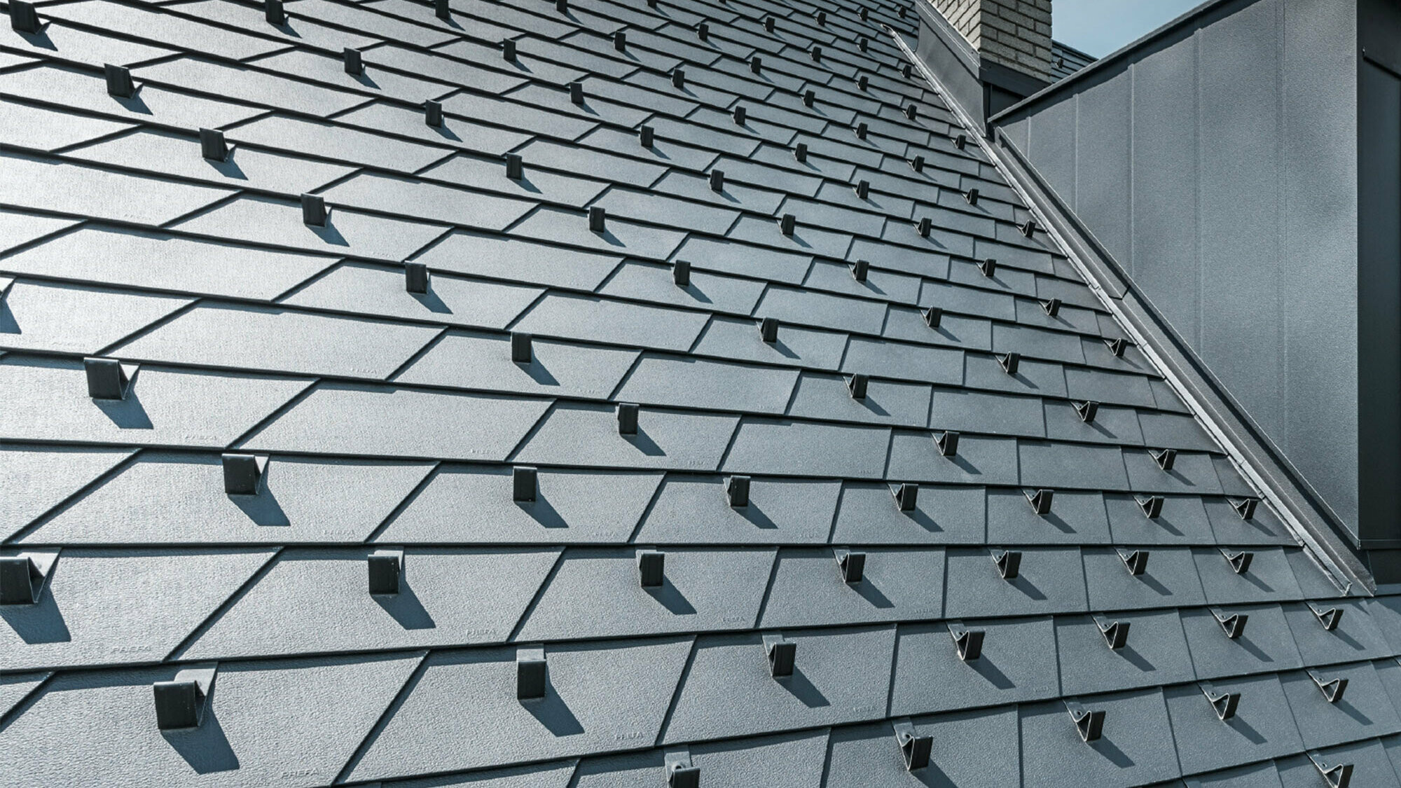 Nowo wyremontowany dach z dachówką łupkową PREFA w kolorze czarnym P.10, łącznie ze stoperami śniegowymi, lukarna pokryta aluminium PREFA