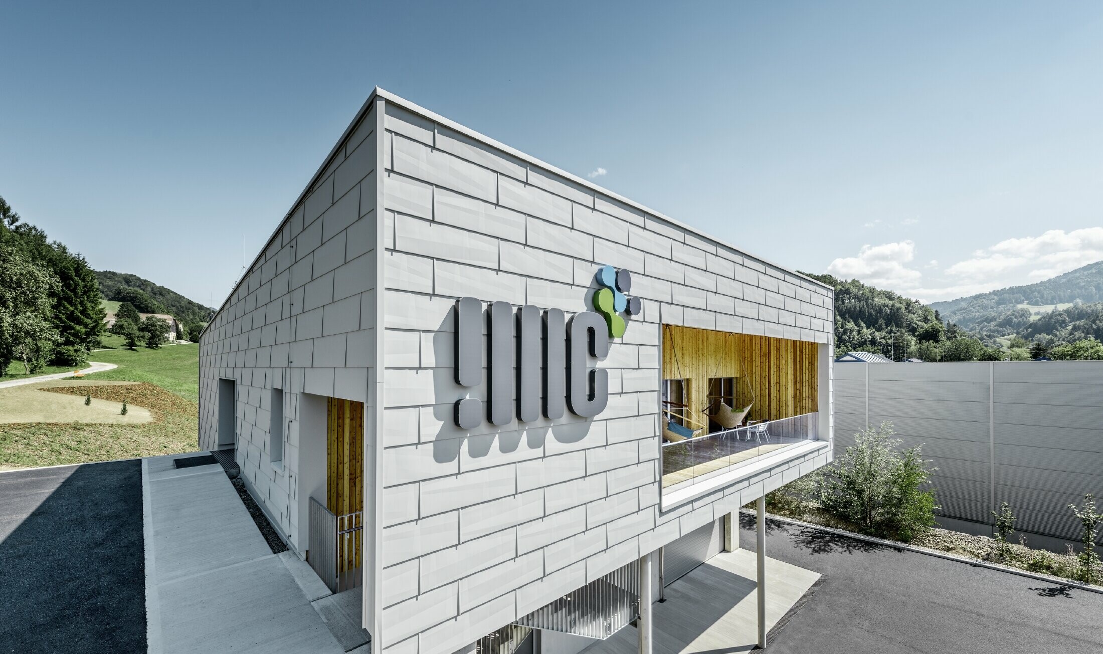 Nowoczesny budynek firmy w Ybbsitz z dachem płaskim i aluminiową elewacją. Elewacja została obłożona panelami elewacyjnymi FX.12 PREFA w kolorze białym PREFA.