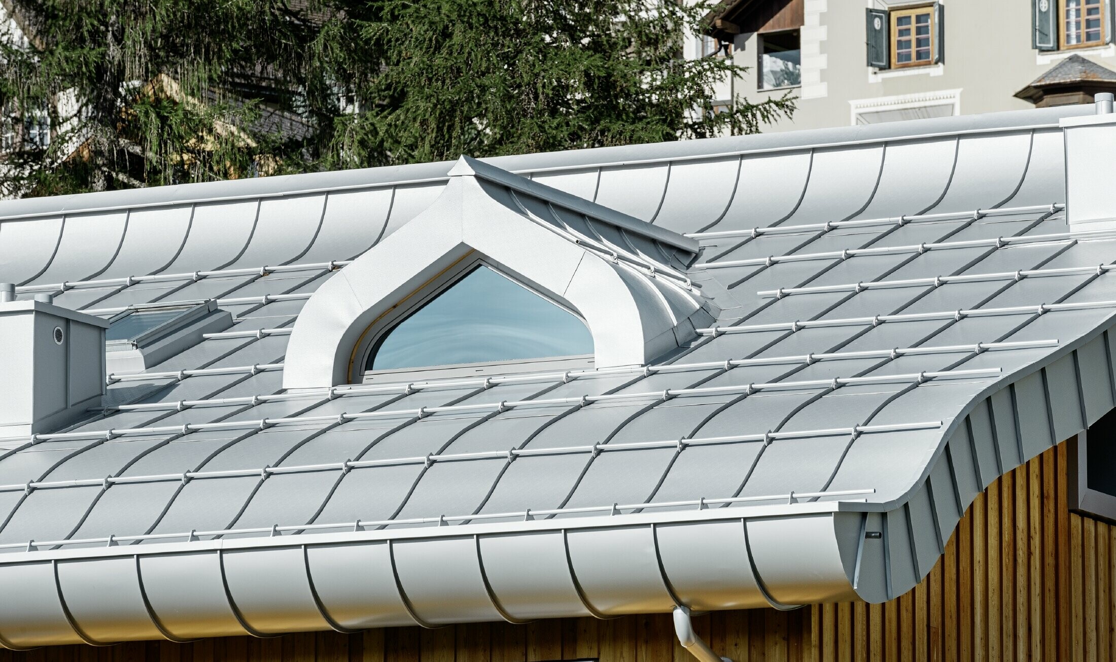 Osiedle mieszkaniowe w St. Moritz z drewnianą elewacją i dachem aluminiowym z łukowatym okapem w kolorze srebrny metallic