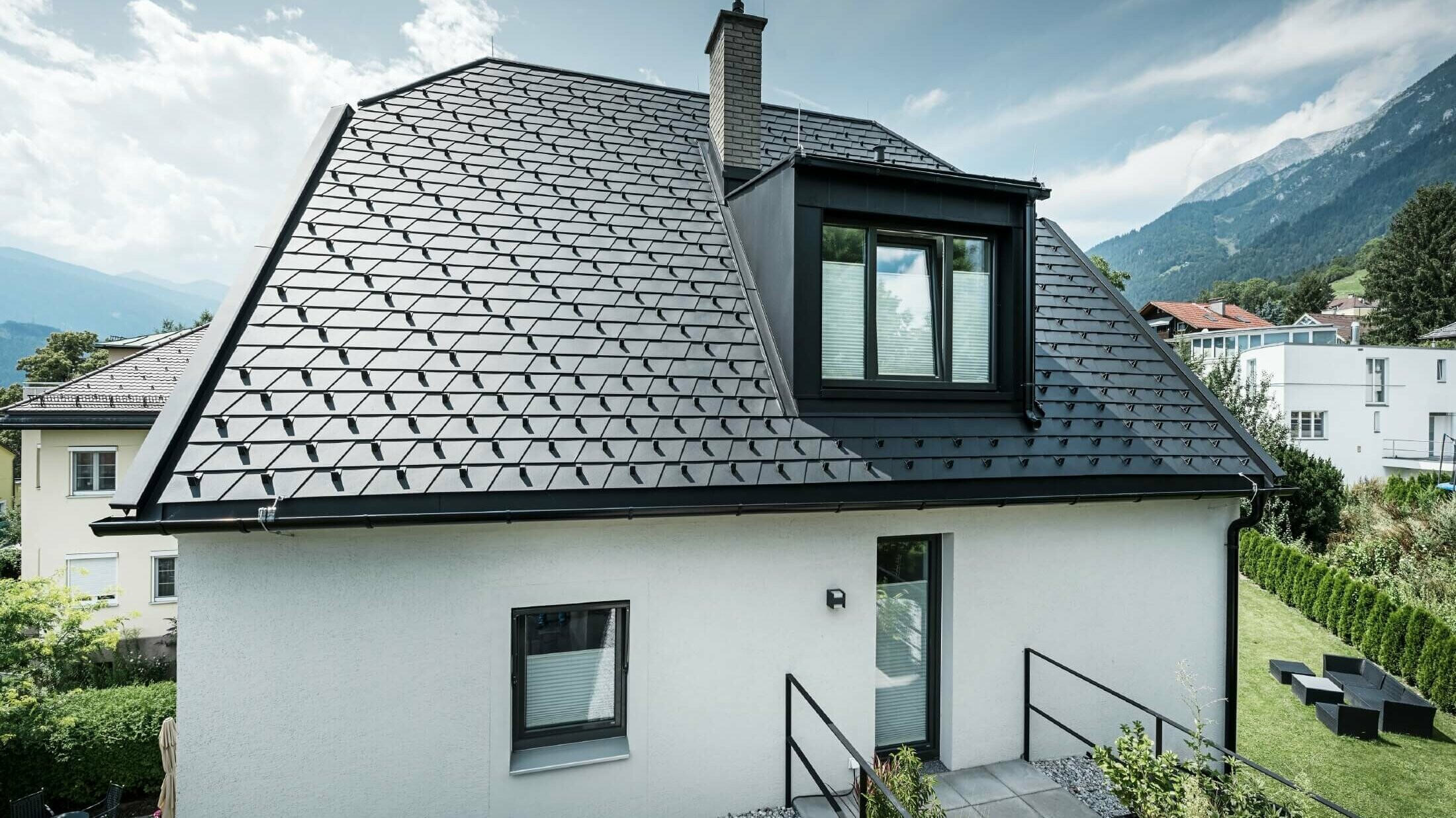 Mały dom jednorodzinny z lukarną. Dach został pokryty dachówką łupkową PREFA w kolorze P.10 czarny. 
