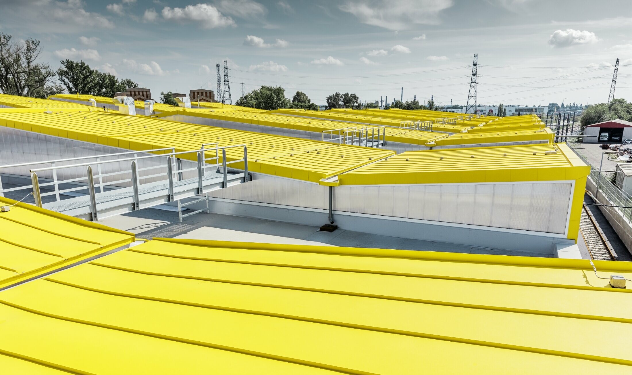 Detal żółtej połaci dachowej nowej budapeszteńskiej zajezdni tramwajowej z dachem na rąbek stojący PREFA;