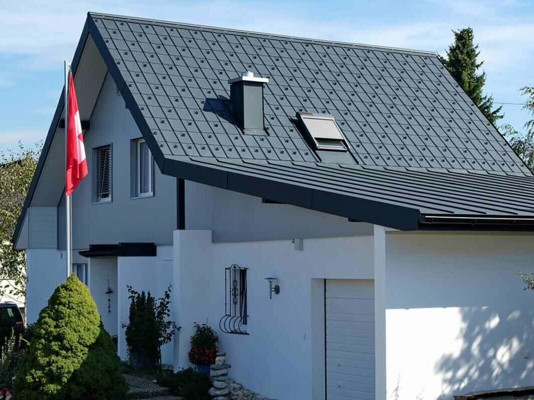 Dom z garażem po modernizacji dachu z płytą dachową PREFA w kolorze antracytowym