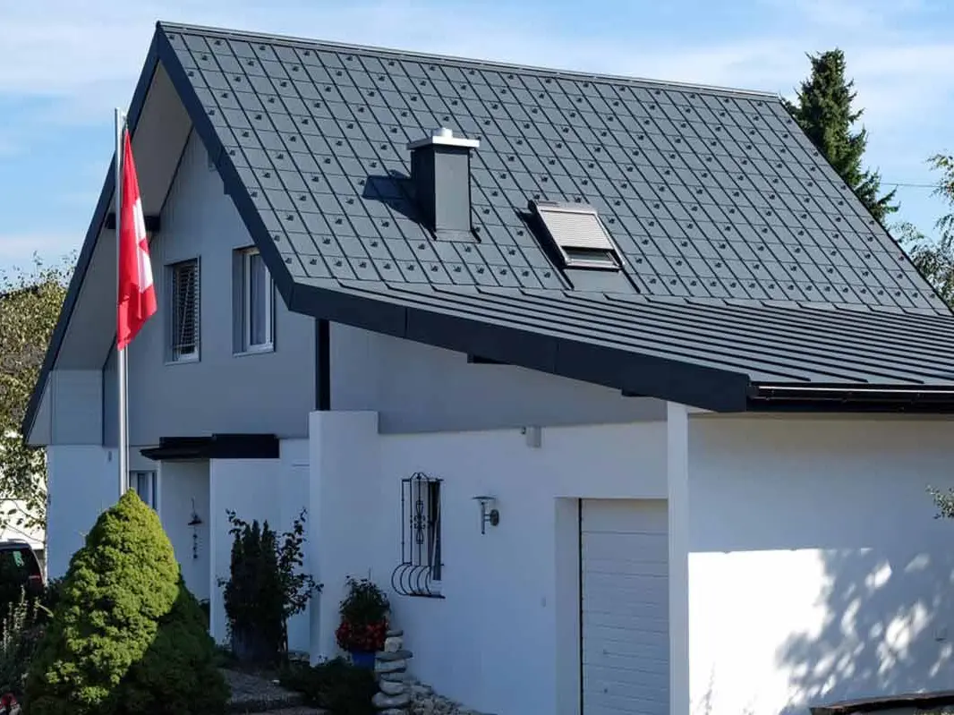 Dom z garażem po modernizacji dachu z płytą dachową PREFA w kolorze antracytowym