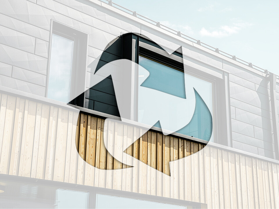 Zdjęcie przedstawia symbol recyklingu przed fasadą domu z aluminiowymi elementami PREFA i drewnianymi panelami.