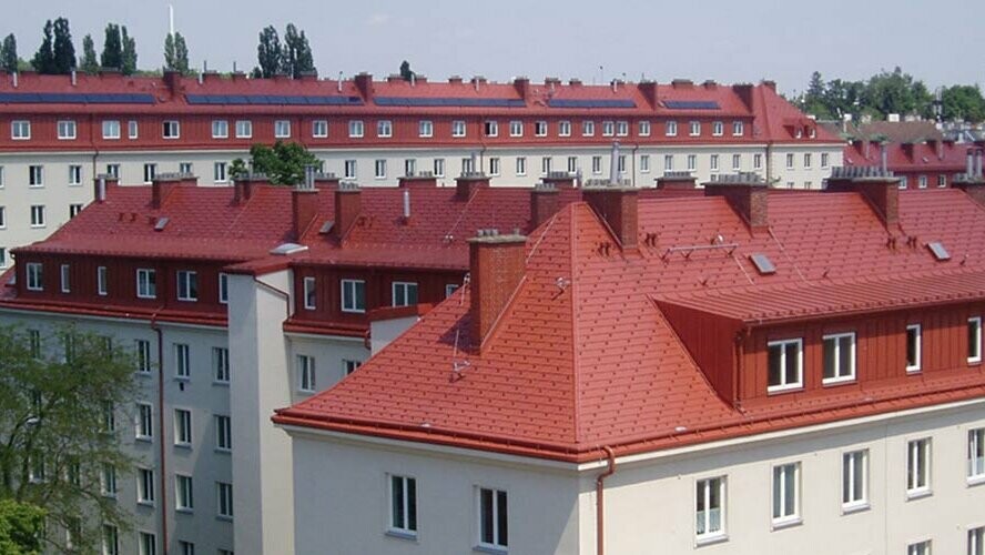 Zdjęcie domów mieszkalnych Hugo Breitner Hof w Wiedniu. Dachy pokryto dachówką łupkową PREFA w kolorze ceglastym.
