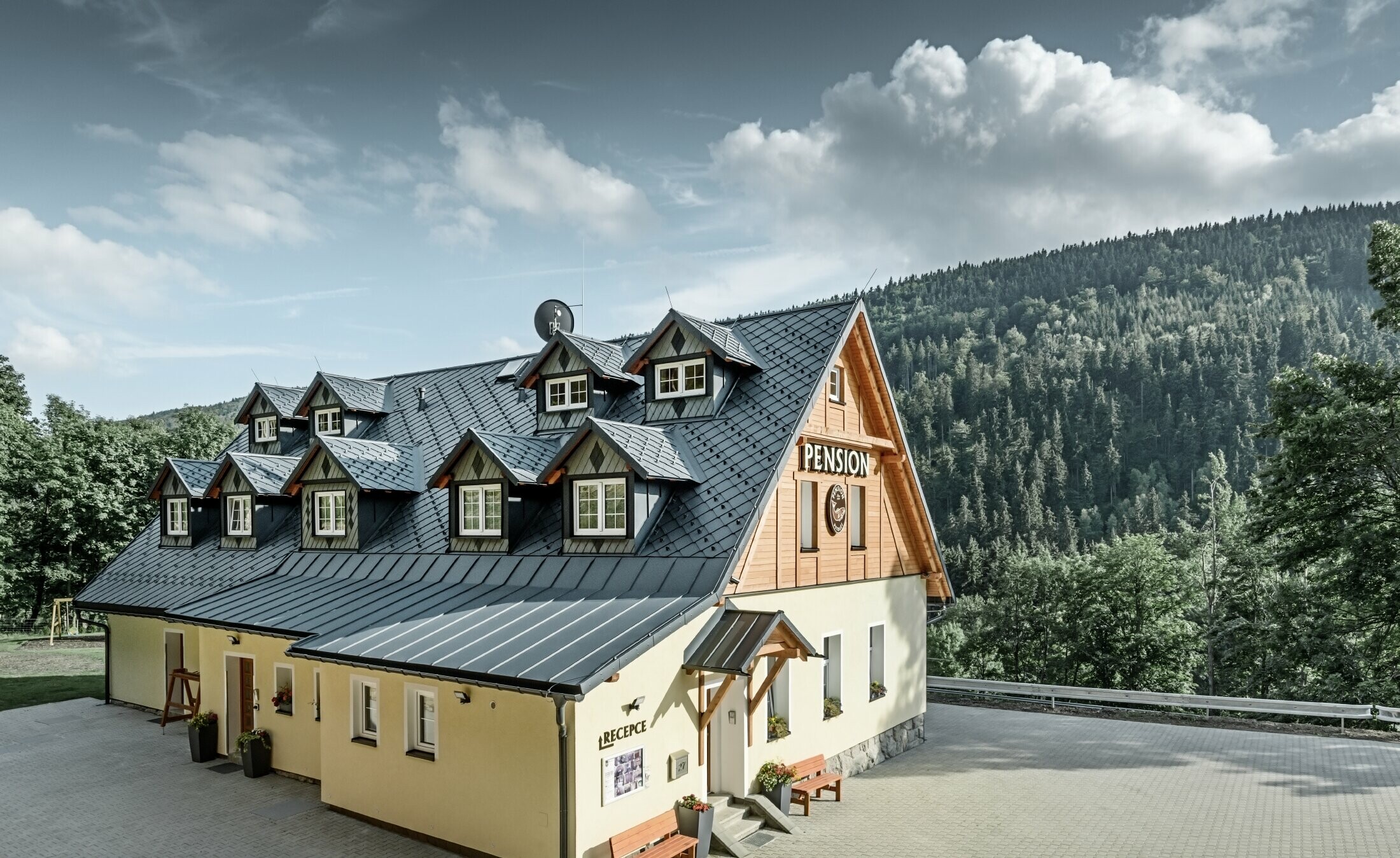 Pensjonat w Czechach z dachem stromym, pokryty wieloma lukarnami z dachem aluminiowym PREFA, dach rombowy w formie łusek z ochroną przeciwśniegową