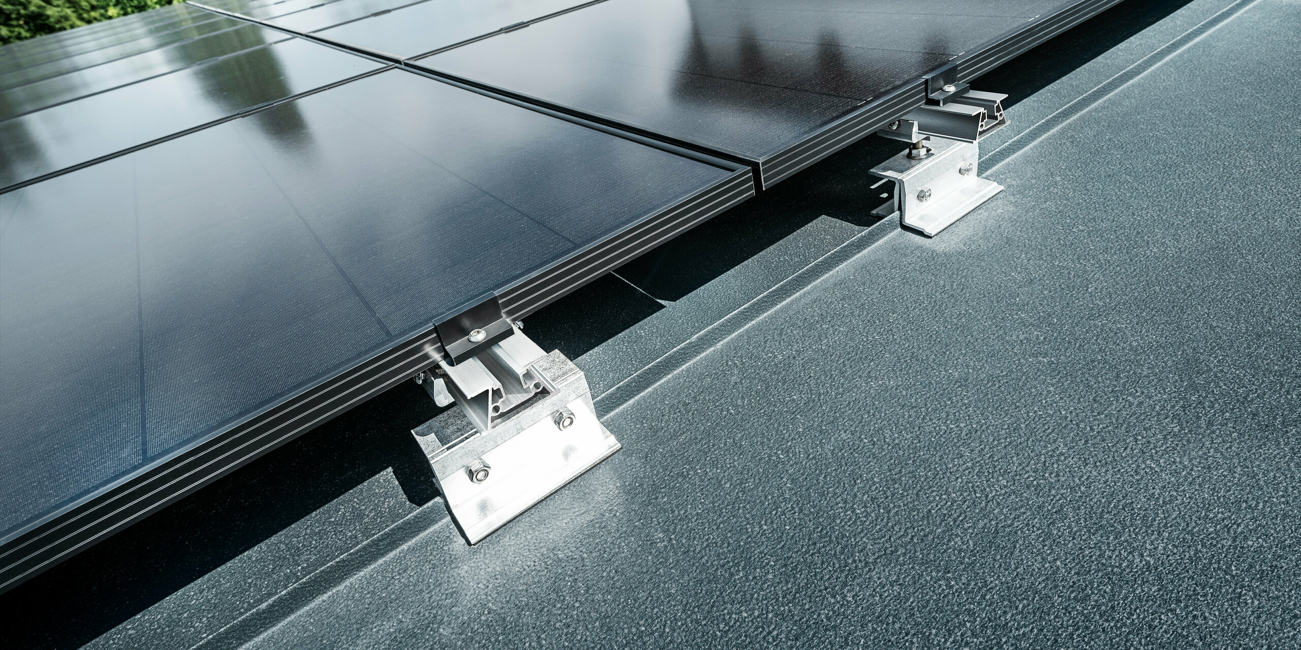 Zbliżenie wspornika solarnego PREFA PREFALZ Vario na dachu z rąbkiem stojącym w kolorze antracytowym 