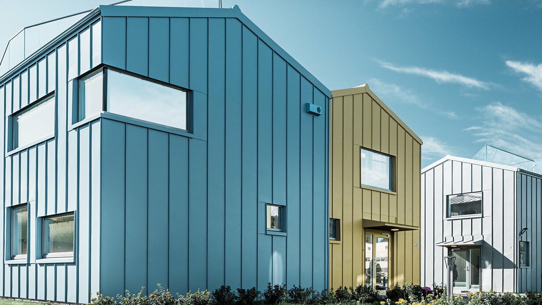 Osiedle domów jednorodzinnych z kolorowymi dachami i elewacjami wykonanymi z aluminium 