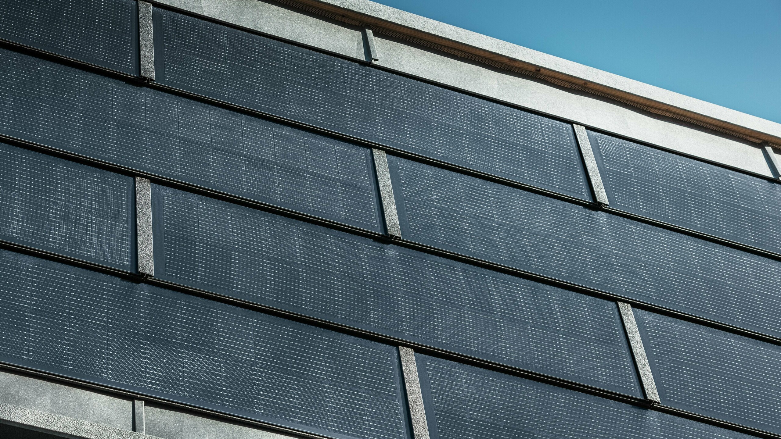 Szczegółowy widok paneli słonecznych PREFA na elewacji budynku biurowego RUEMA.