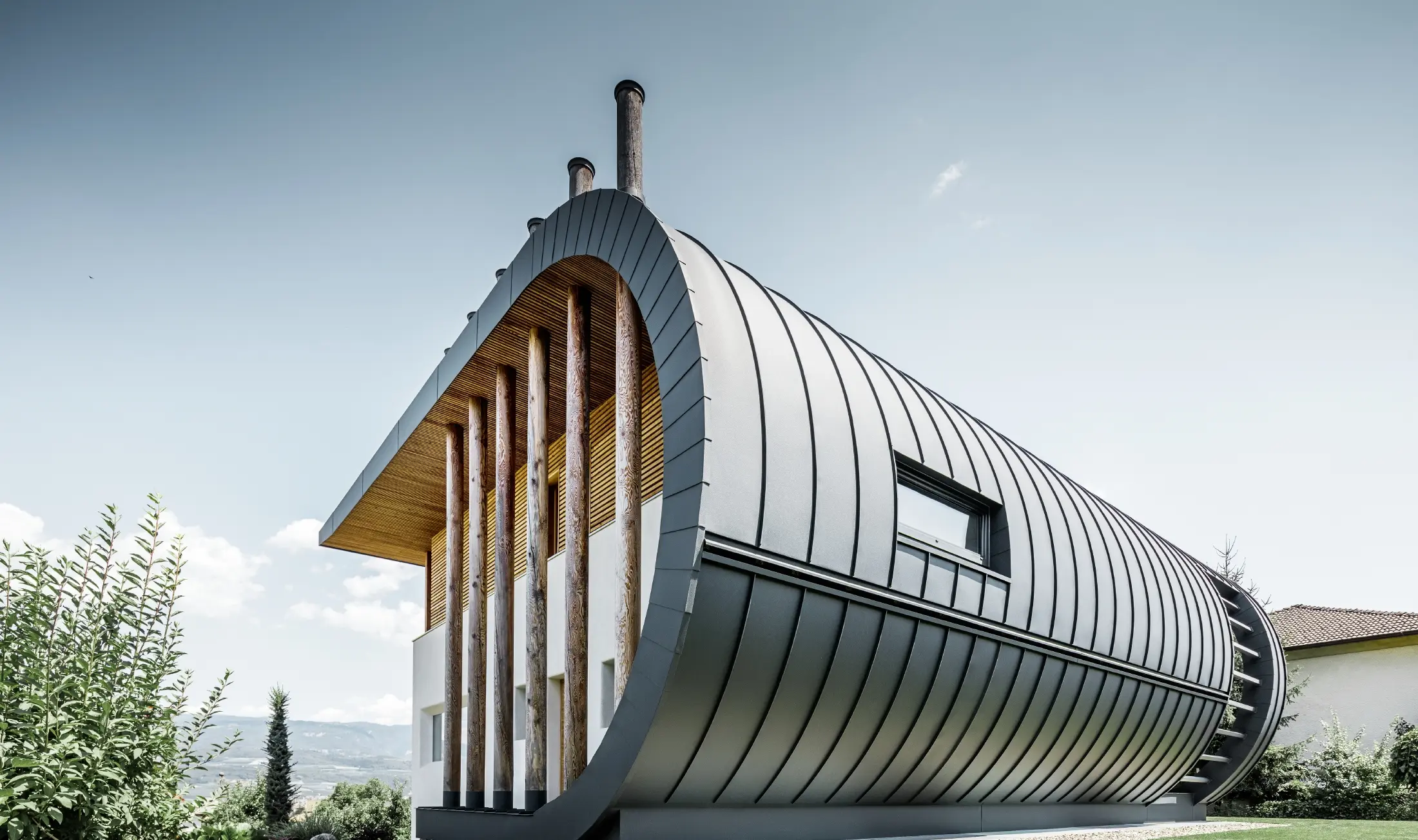 Zakrzywiona elewacja domu jednorodzinnego Casa Giovannini pokryta aluminium w systemie Prefalz PREFA w kolorze antracytowym P.10.