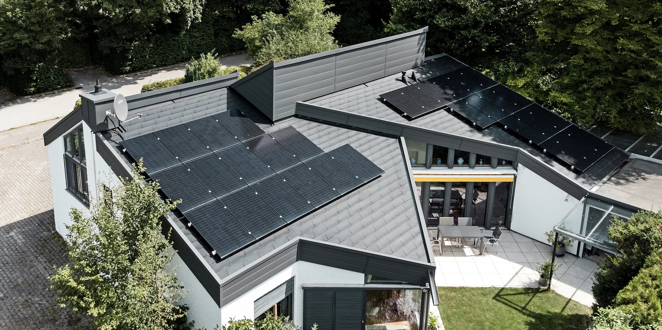 Ein Einfamilienhaus, das mit PREFA Dachschindeln DS.19 in schwarz eingedeckt wurde. Für Teile der Fassade wurden PREFA Sidings in P.10 dunkelgrau verwendet. 