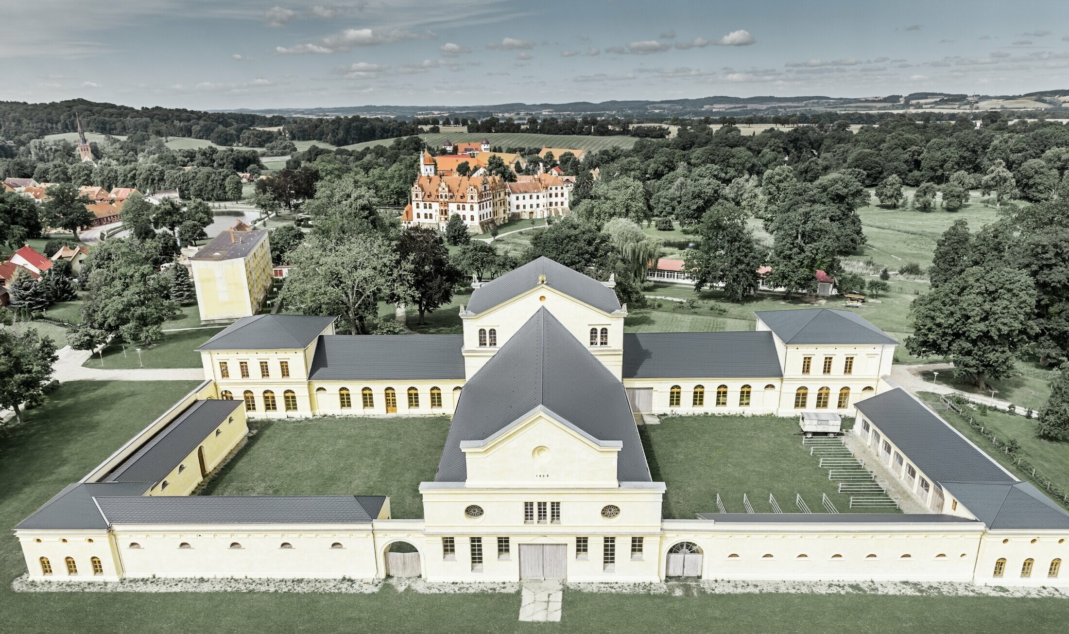 Zdjęcie z lotu ptaka stadniny w Basedow; wyremontowany pałac w stylu renesansowym ma nowy dach z dachówki łupkowej PREFA w kolorze antracytowym.