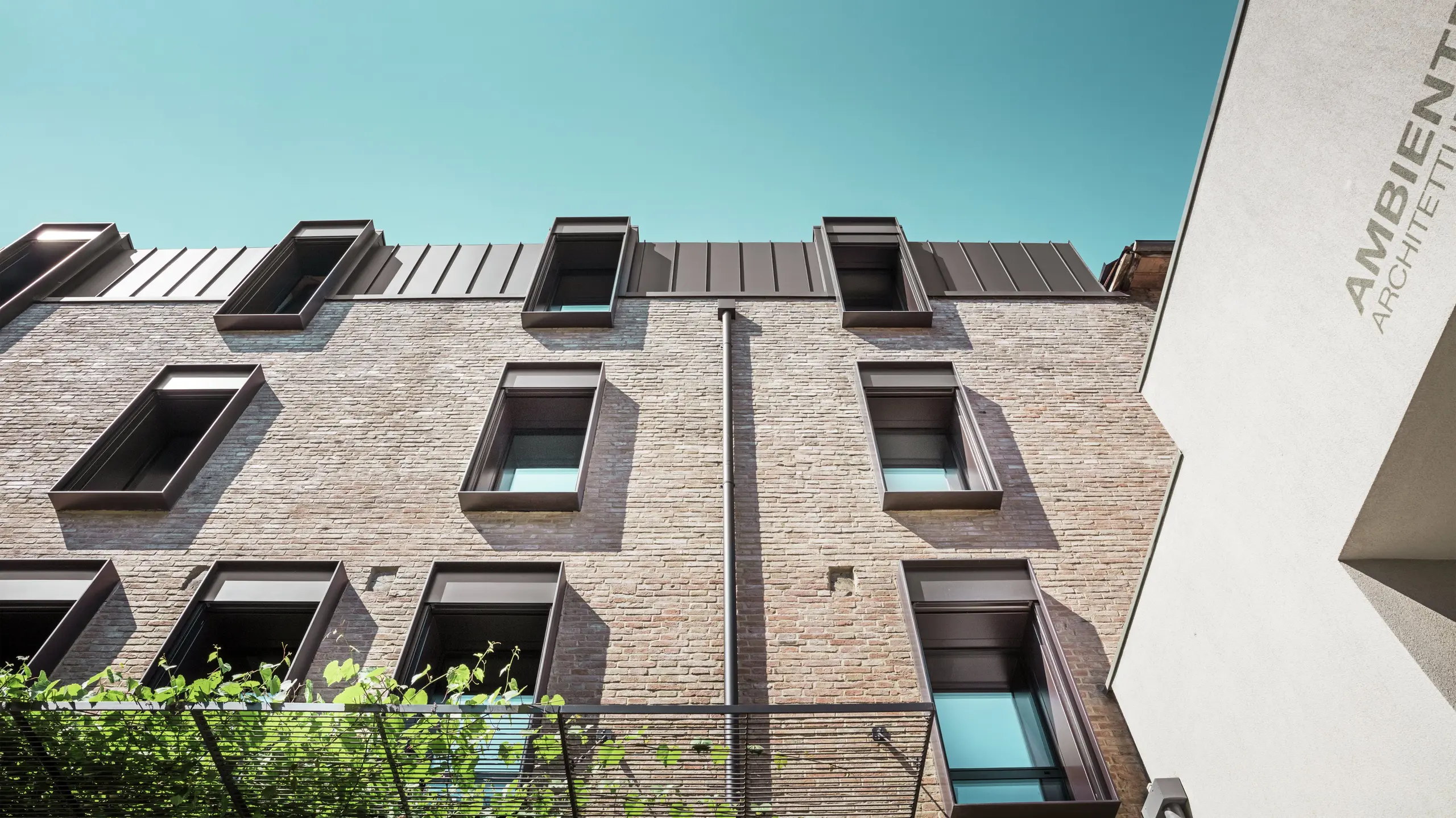Tradycyjny dom z cegły we Włoszech z trwałym dachem aluminiowym PREFALZ w kolorze P.10 orzechowy brąz – harmonijne połączenie śródziemnomorskiej architektury i nowoczesnego rozwiązania dachowego.