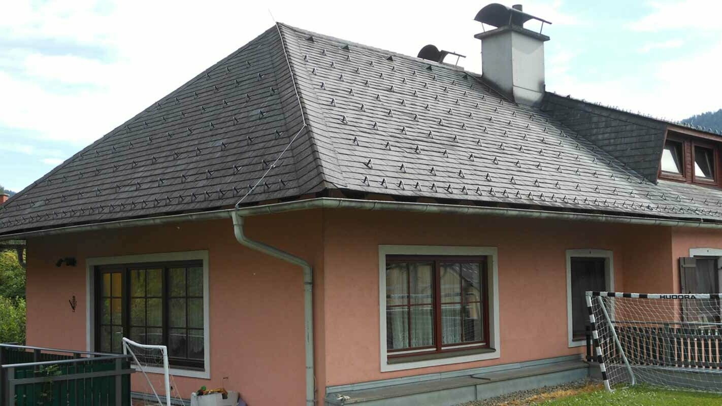 Dach czterospadowy przed modernizacją domu z trapezowym oknem dachowym przy zastosowaniu dachówki PREFA